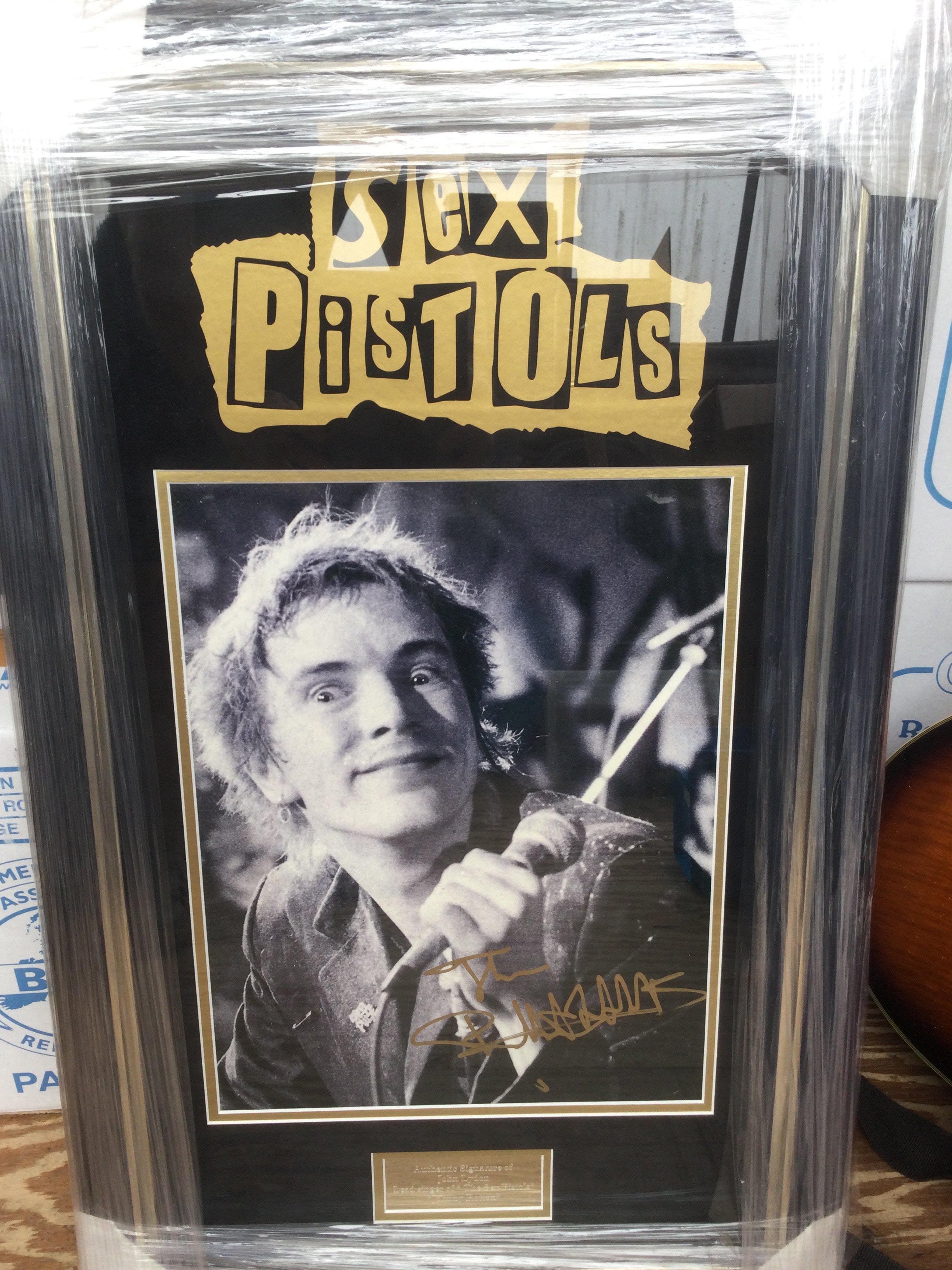 A framed and glazed Sex Pistols display signed by John Lydon with COA, approx 78cm x 48cm.