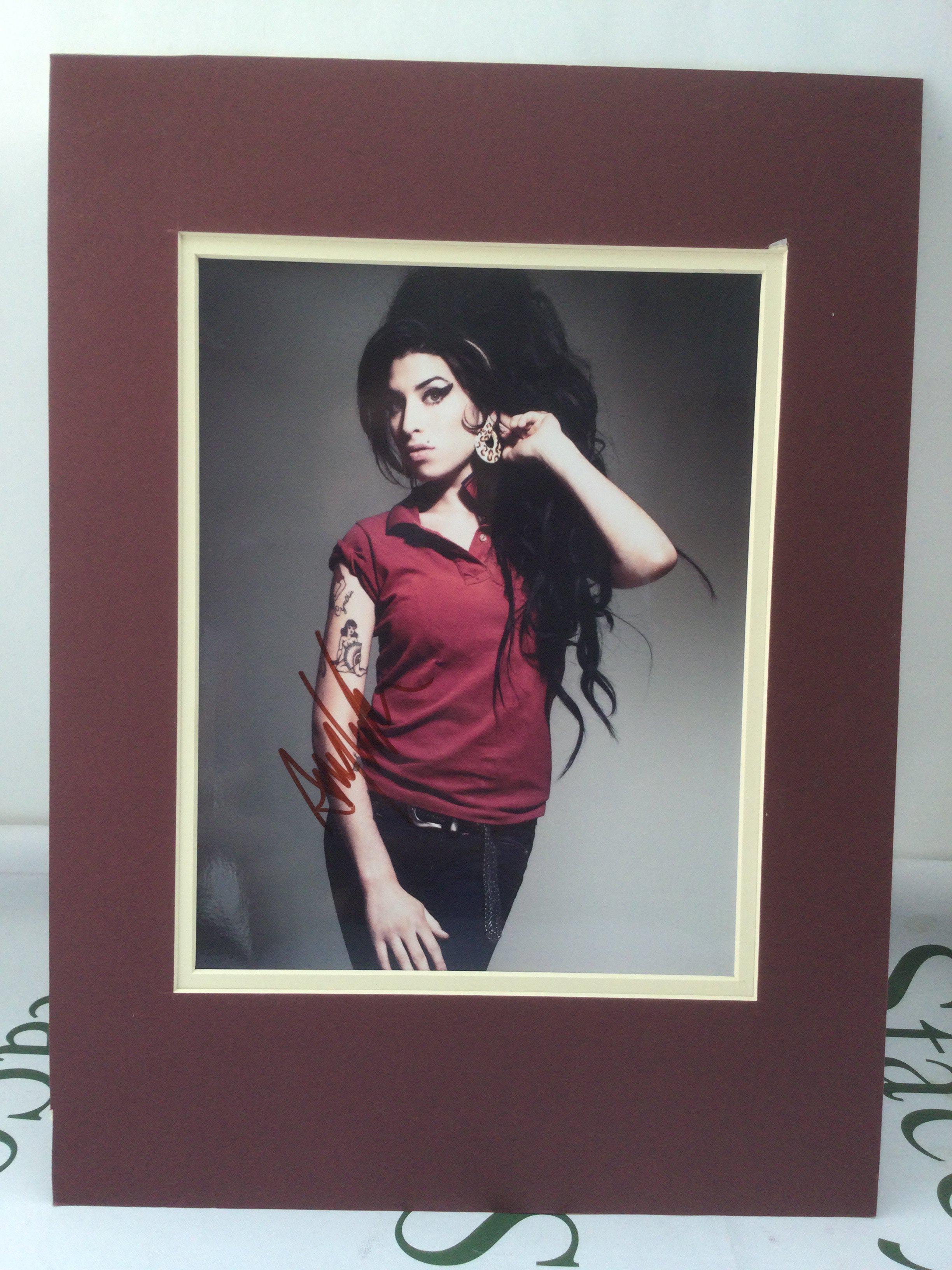 A signed photo of Amy Winehouse with COA.