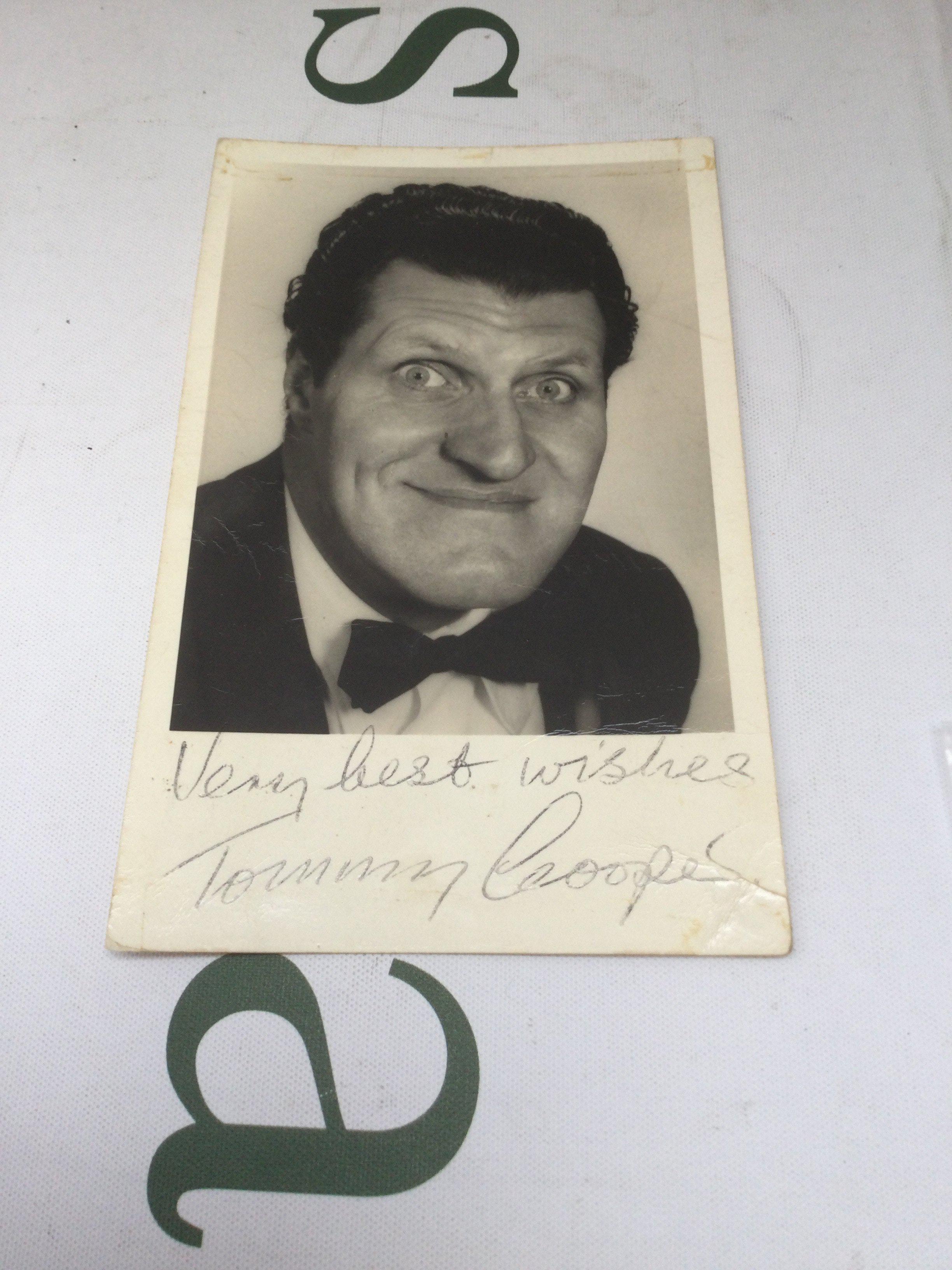 A signed Tommy Cooper photographic card with handwritten notes on the reverse.