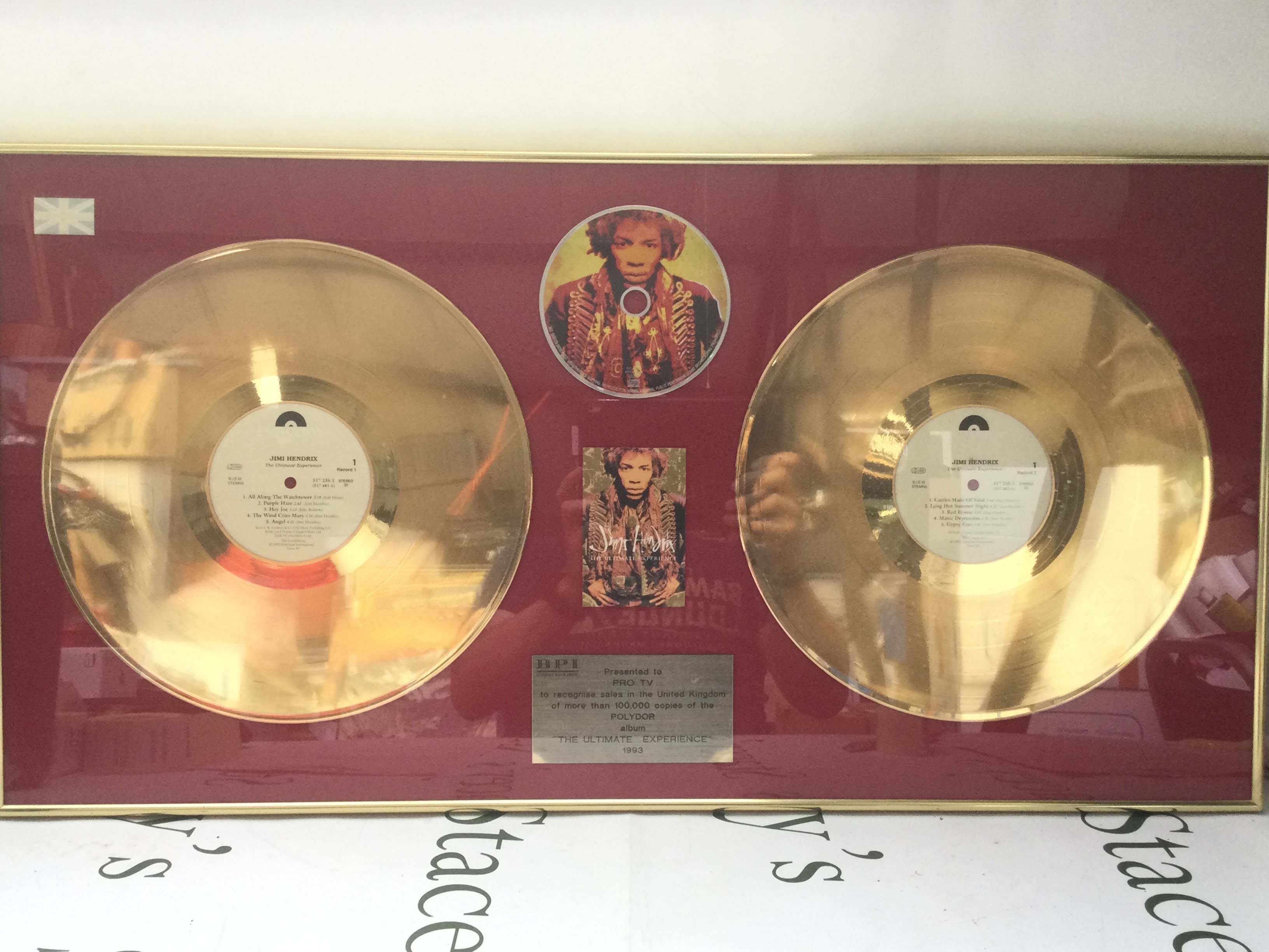 A framed and glazed double gold disc display for the Jimi Hendrix LP The Ultimate experience, approx 80cm x 40cm.