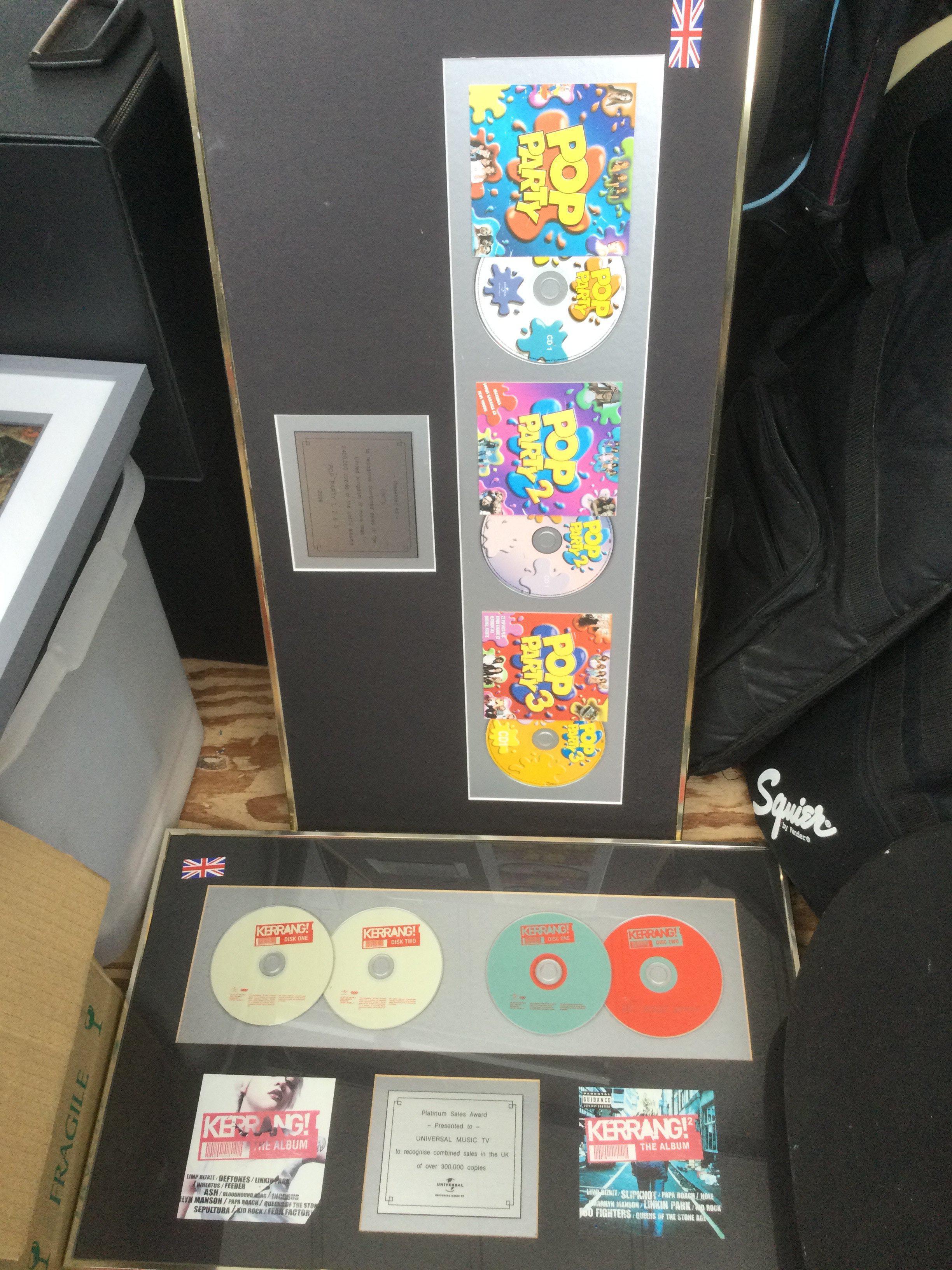 Six framed CD displays for various compilation albums.