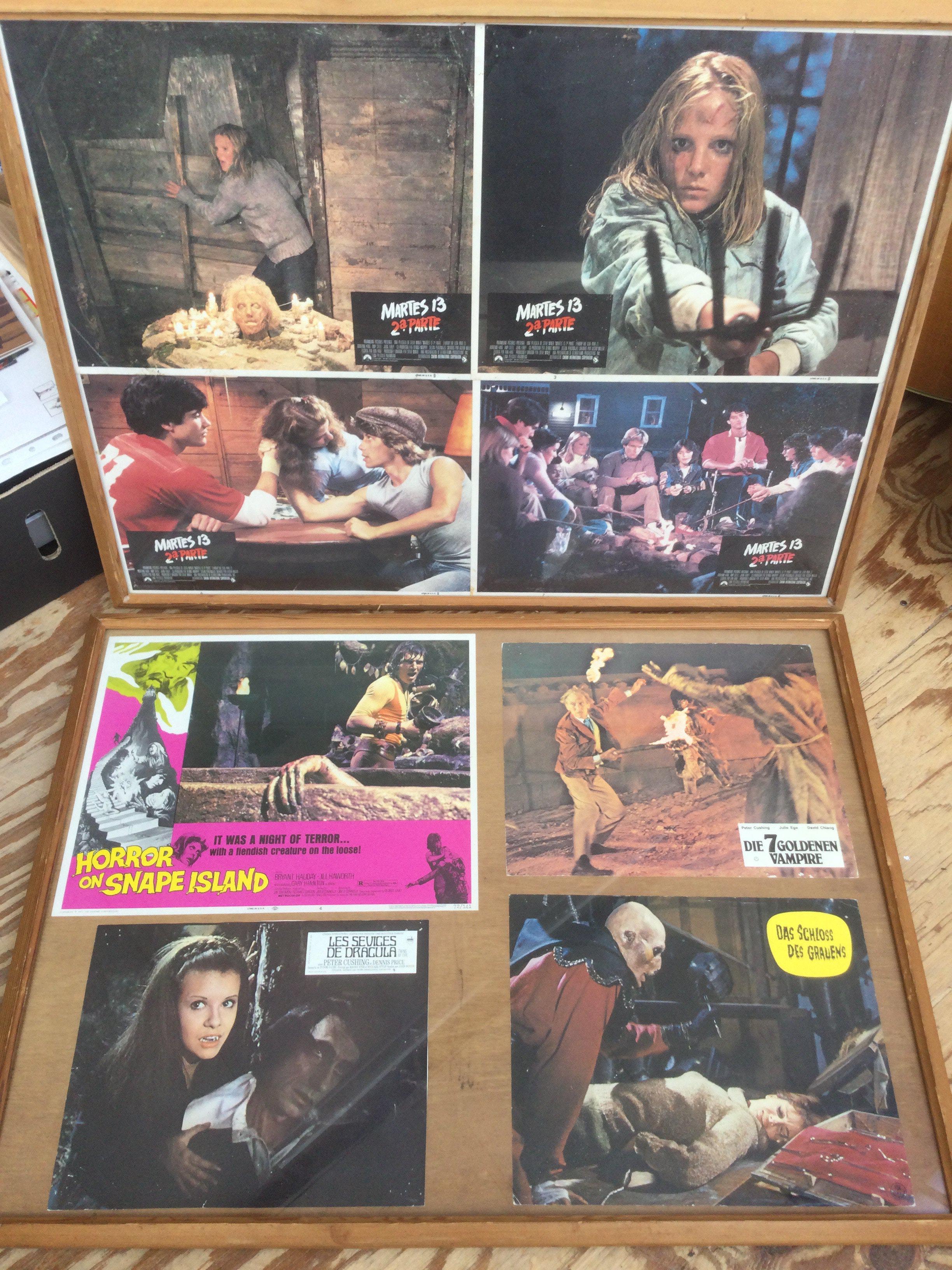 A collection of framed vintage French lobby cards and mini movie posters for various horror films including Jaws 2, Frankenstein 1970, The Haunted Strangler and others.