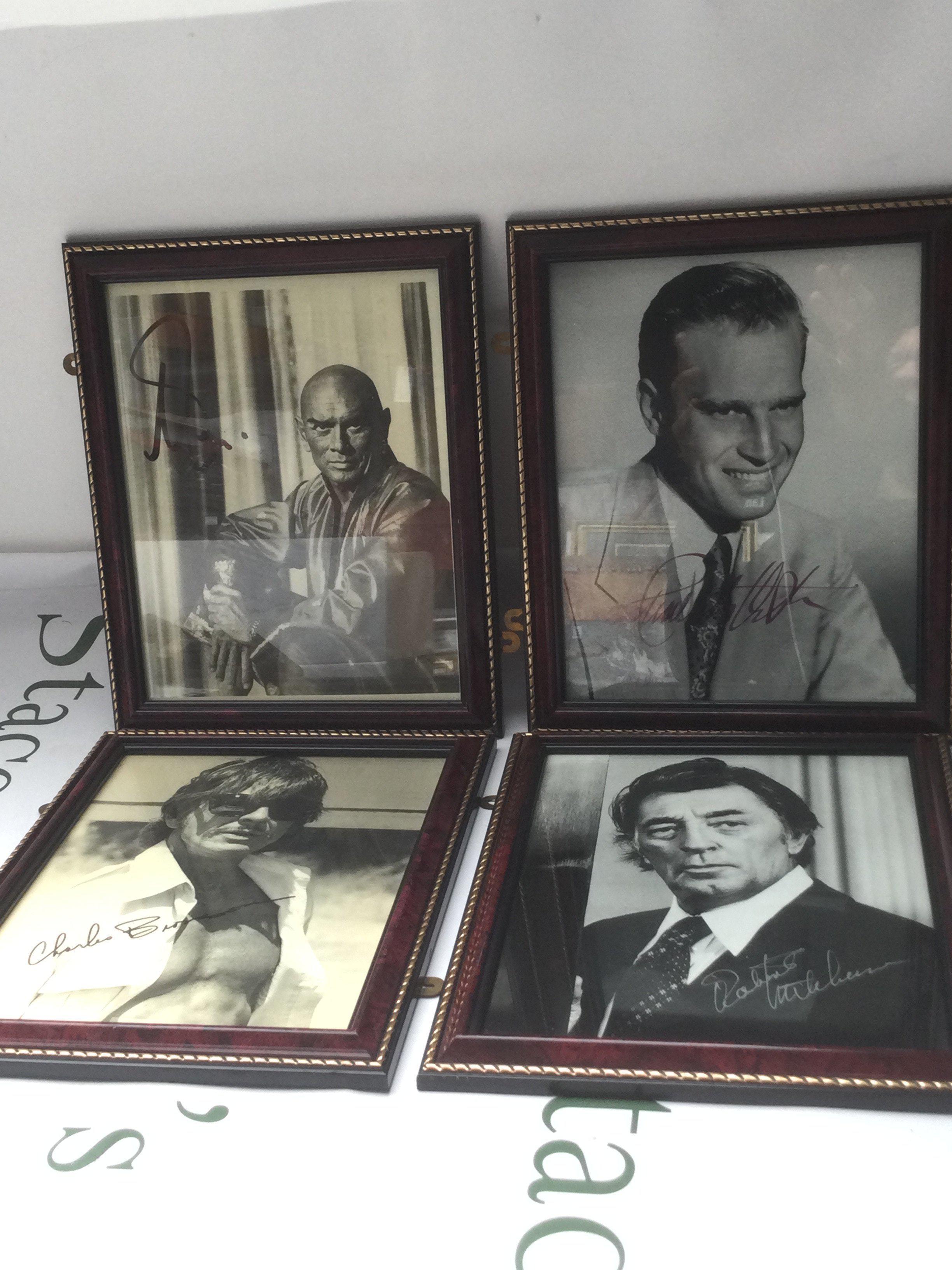 Four framed and signed photos including Charlton Heston, Charles Bronson, Yul Brinner and Robert Mitchum.