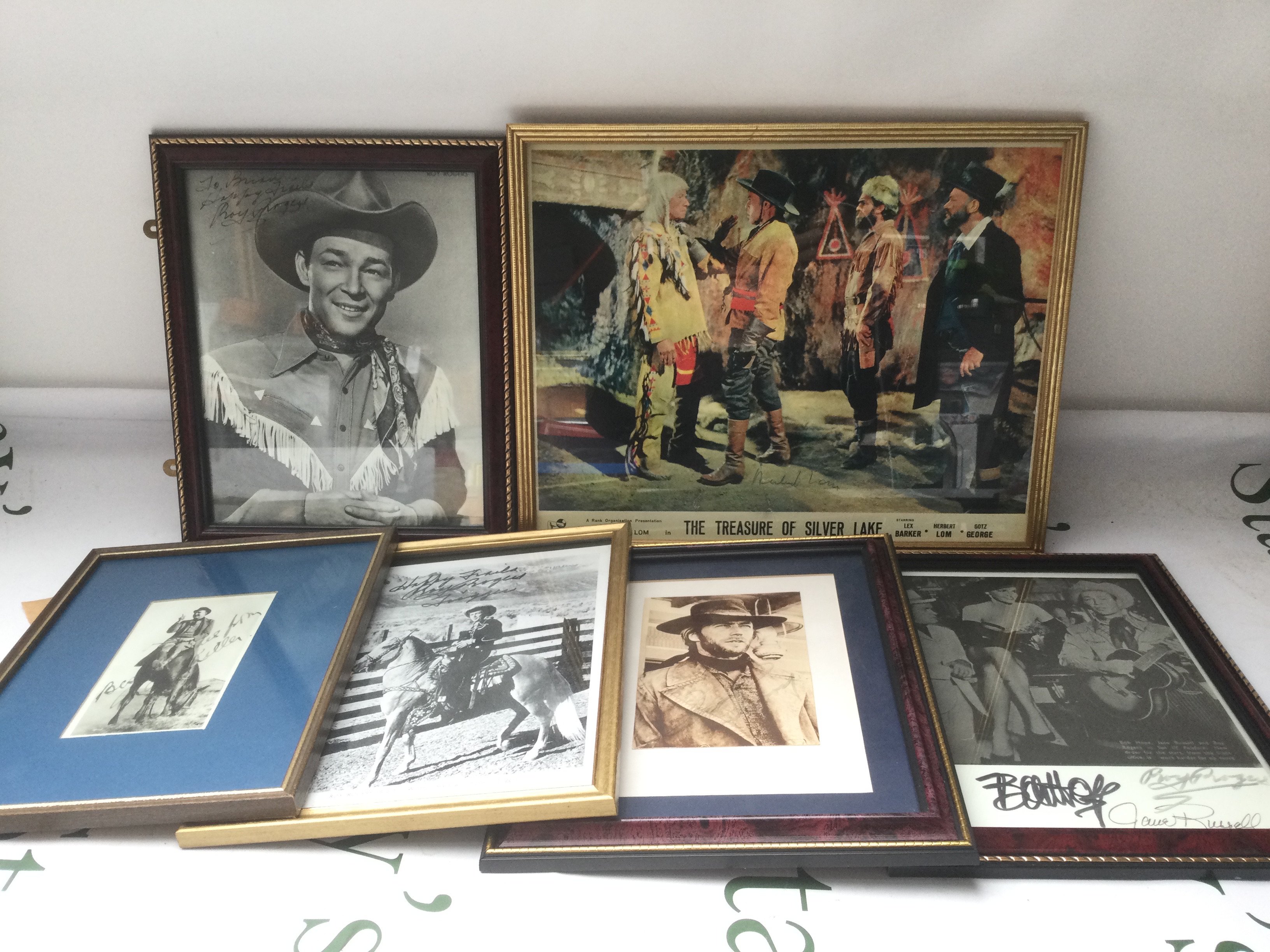 A collection of Western related signed photos and a framed lobby card including Roy Rogers, Clint Eastwood, Jane Russell and others.