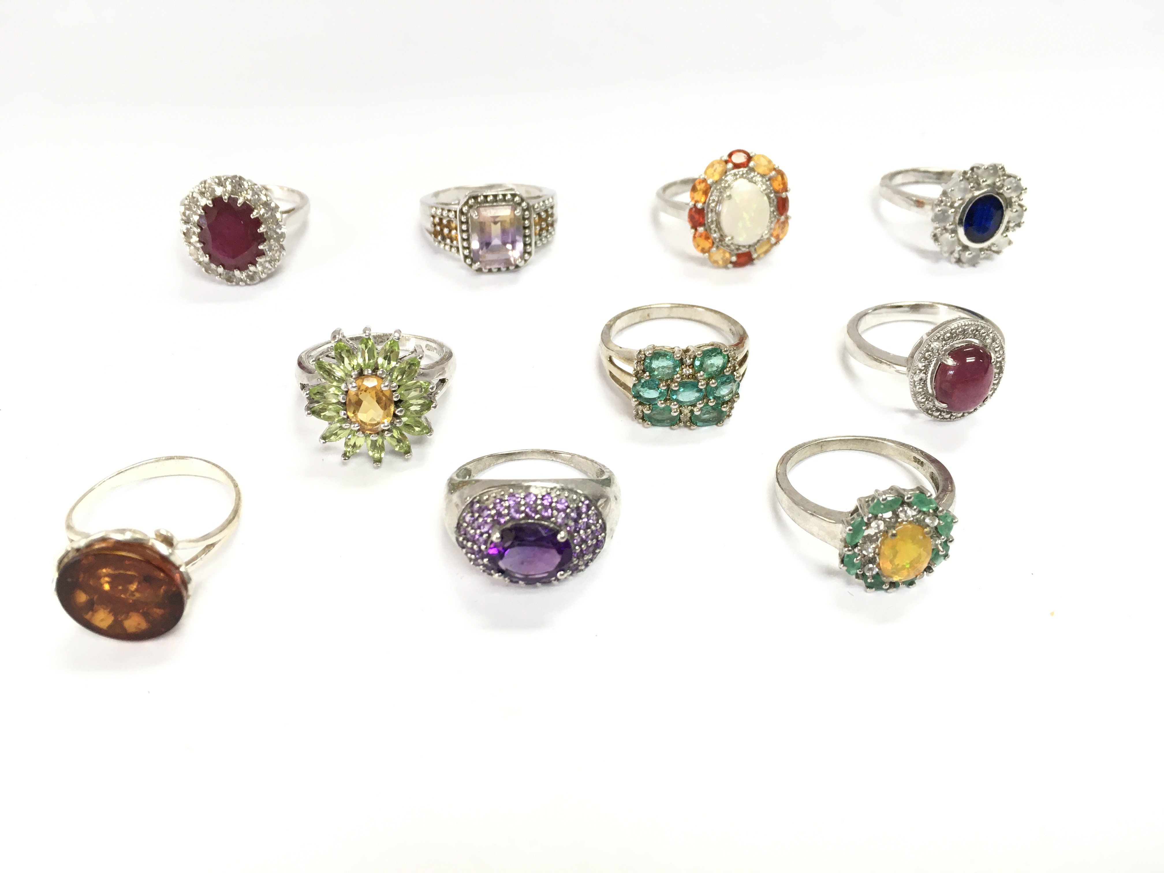 A collection of 10 assorted silver rings set with various stones. Postage B