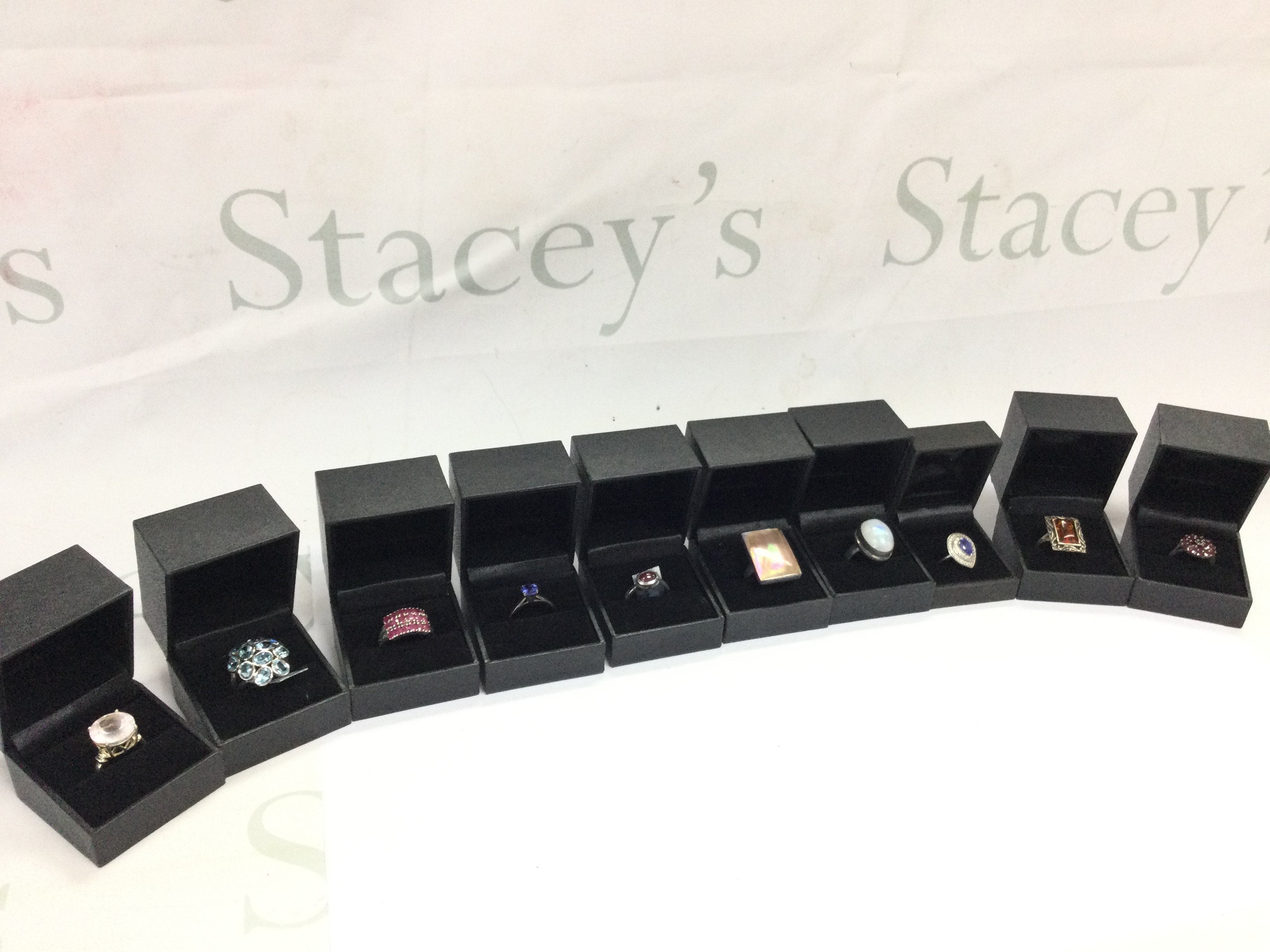 A collection of boxed silver rings set with various gemstones including Sky Blue Topaz, Ruby etc. postage category B