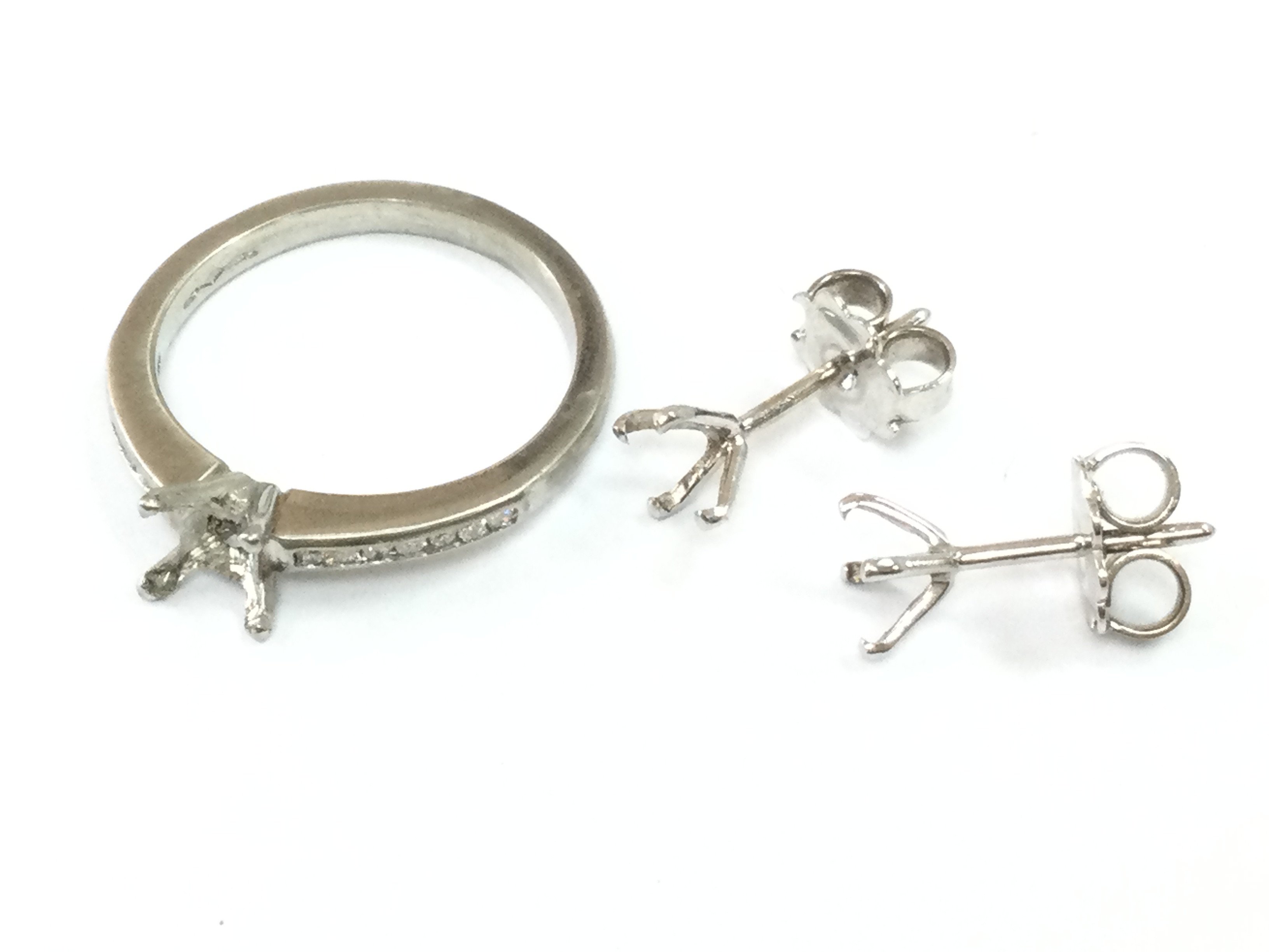A platinum ring set with small diamond shards (3.8g) and a pair of 18ct white gold earrings (1g) .