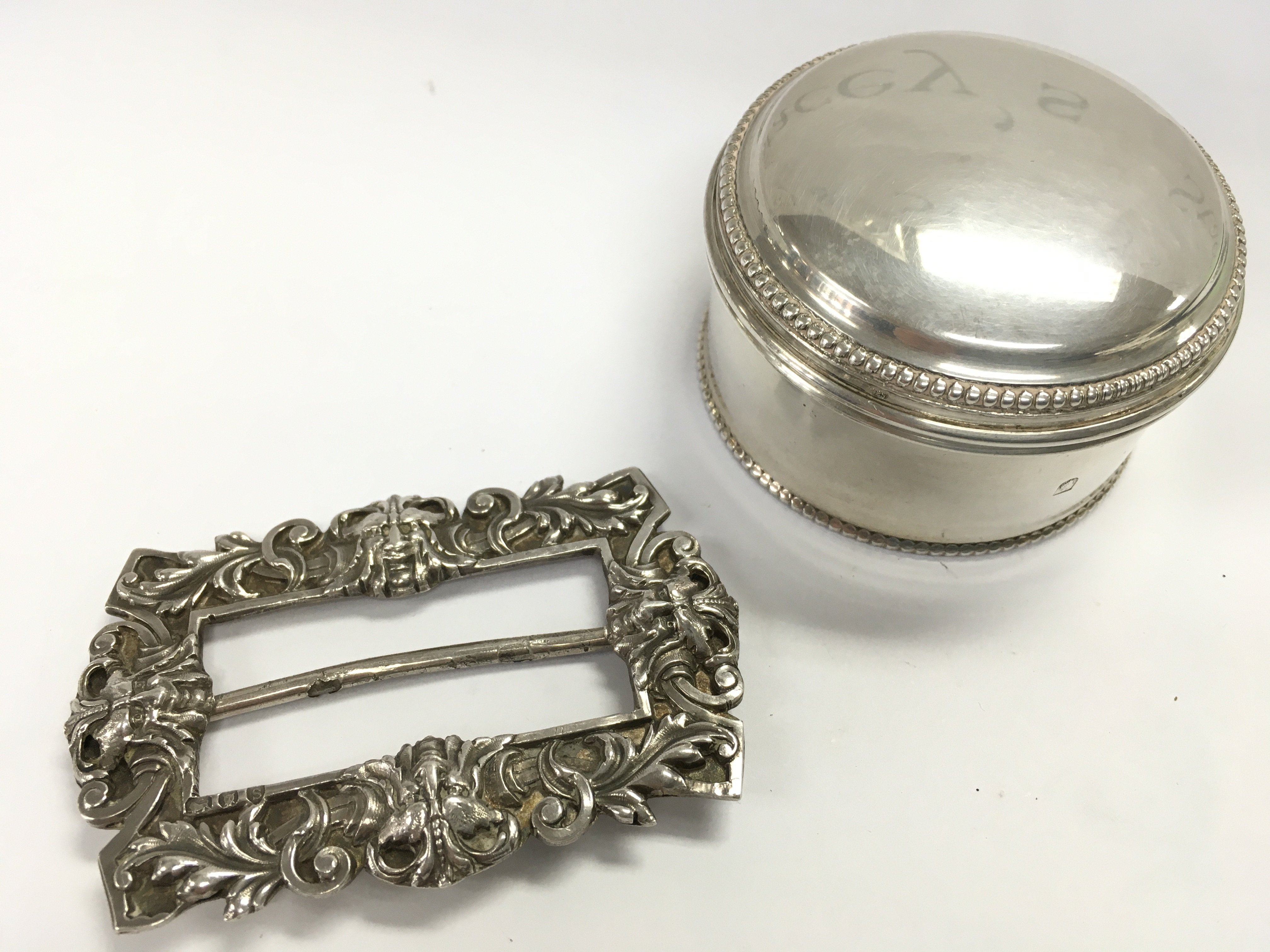 A circular silver hallmarked bead pill trinket box with an 1890s Mappin & Webb buckle . 107.8g Approx total. postage category A