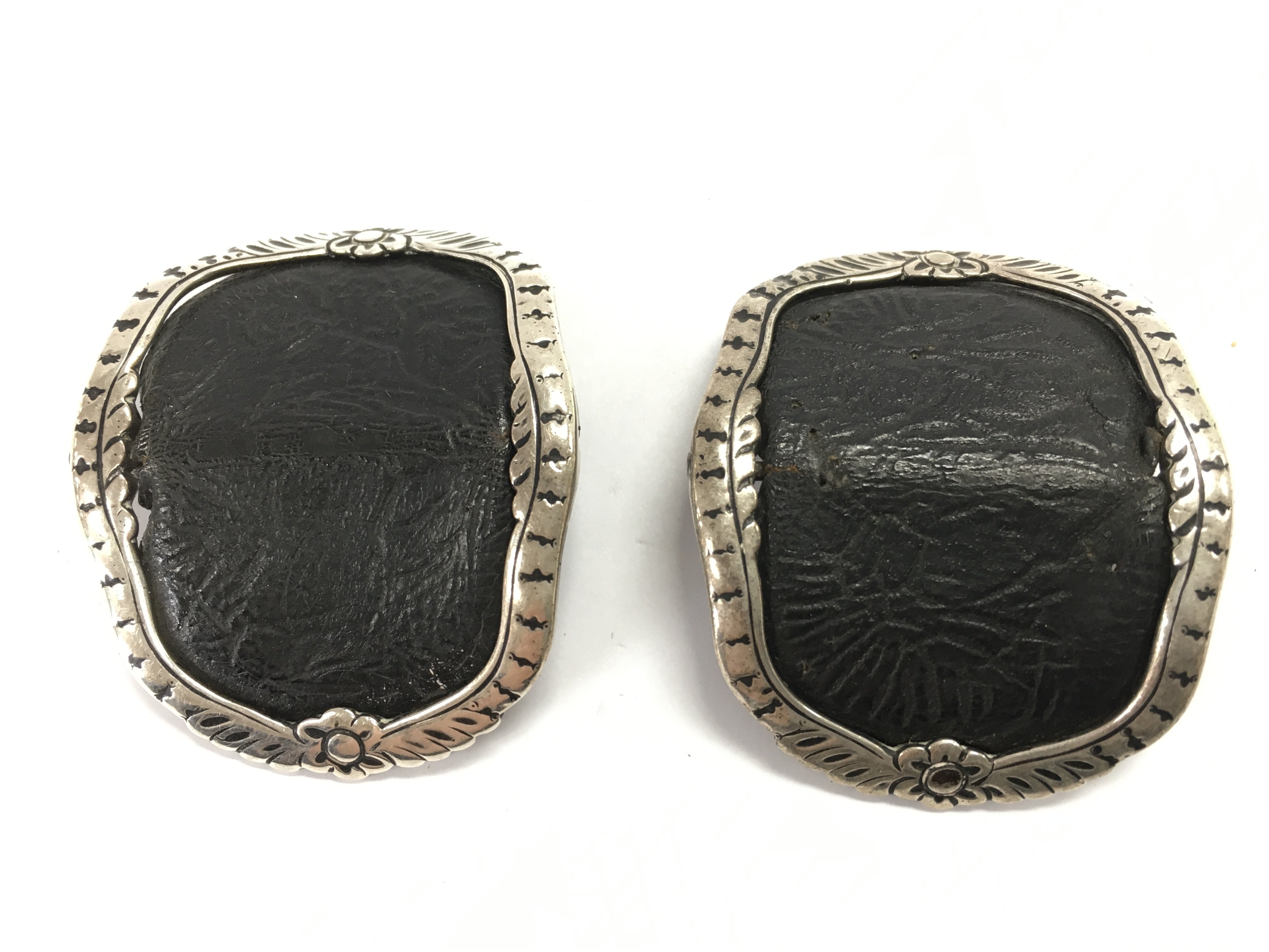 A leather and silver pair of belt buckles . Postage category A