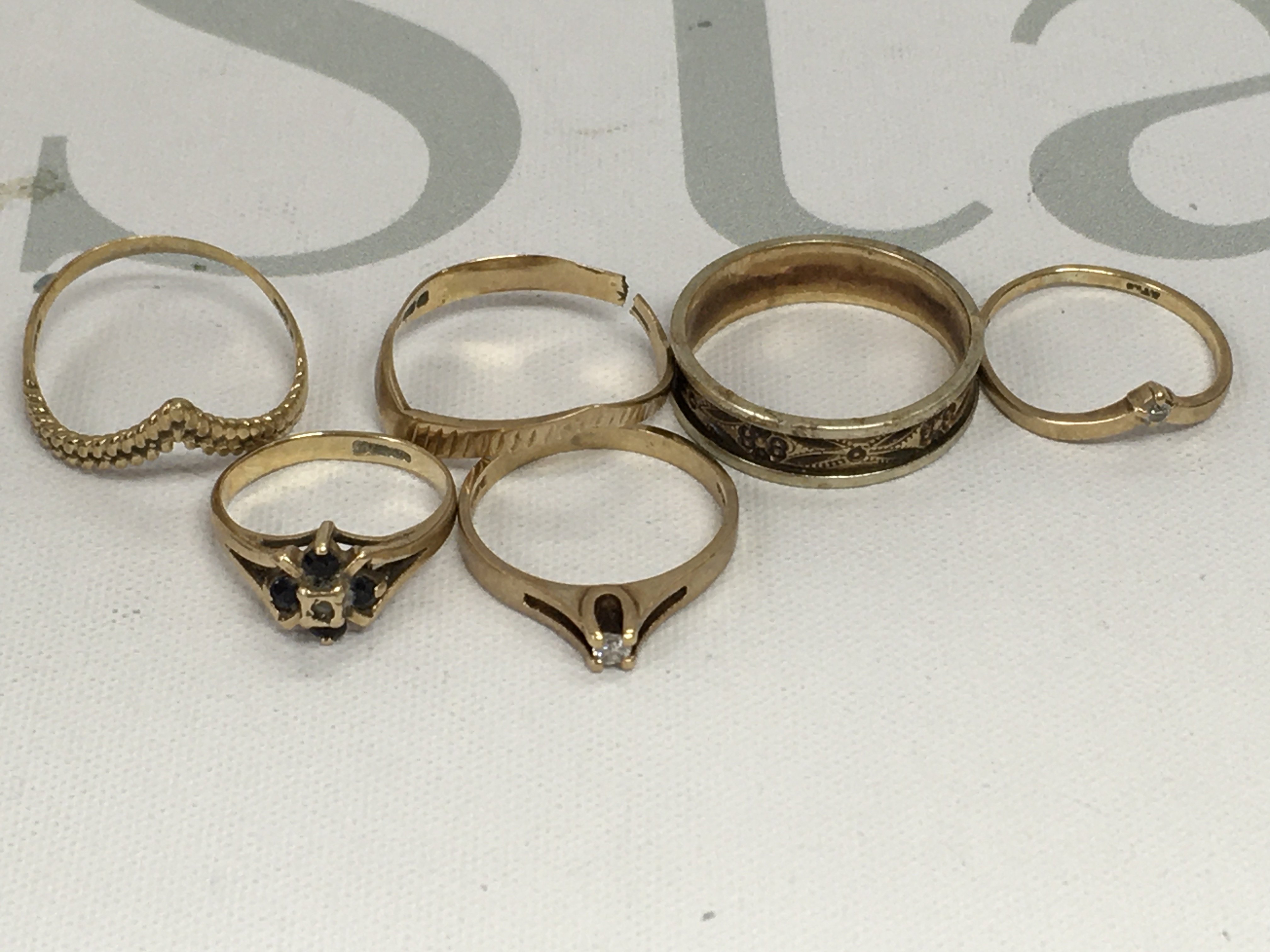 A collection of six 9 ct gold rings including gemstone inset . Total weight 7 grams.