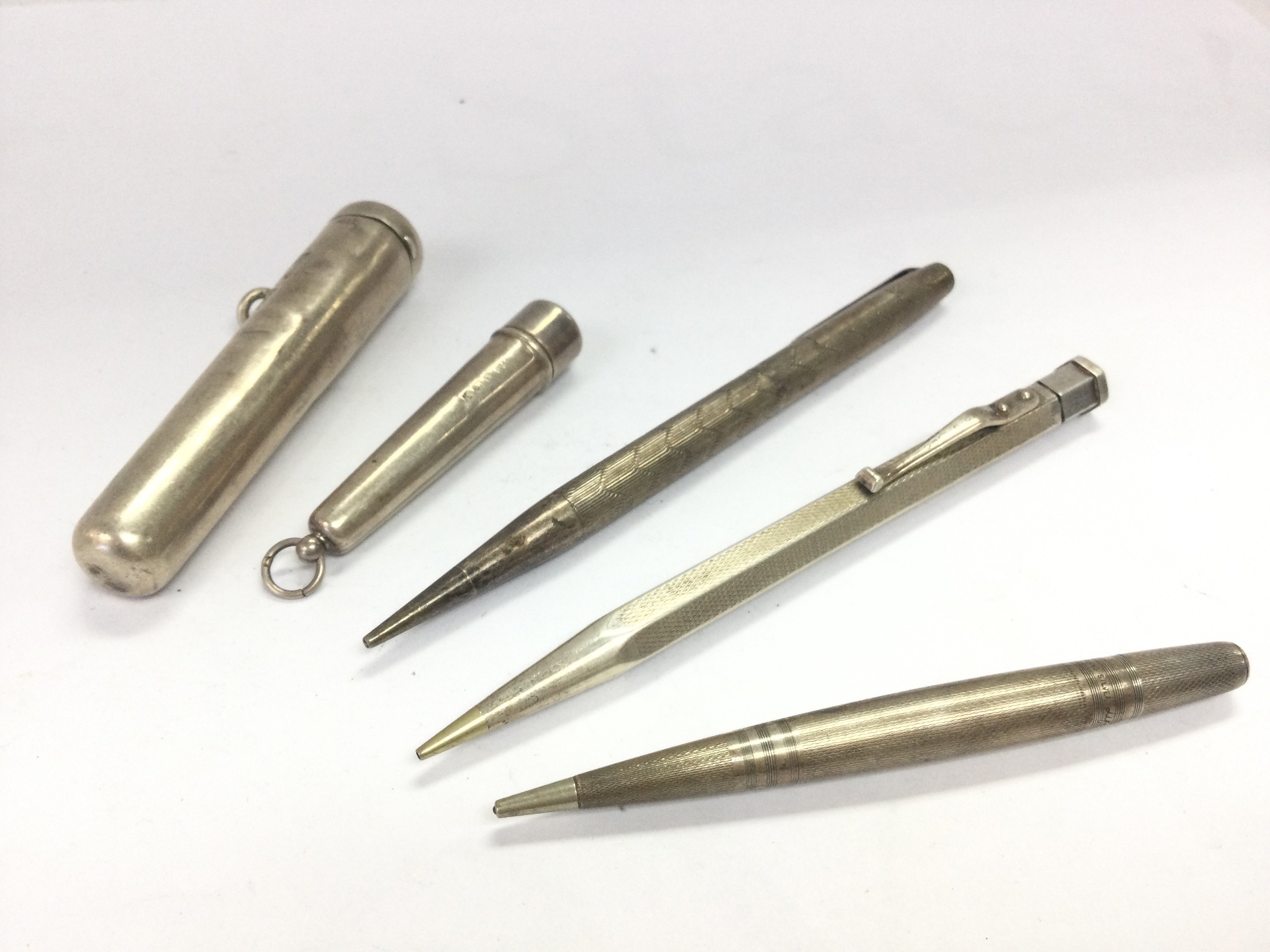 A collection of three silver hallmarked pens and two silver cigar / cigarette holders. Postage category A