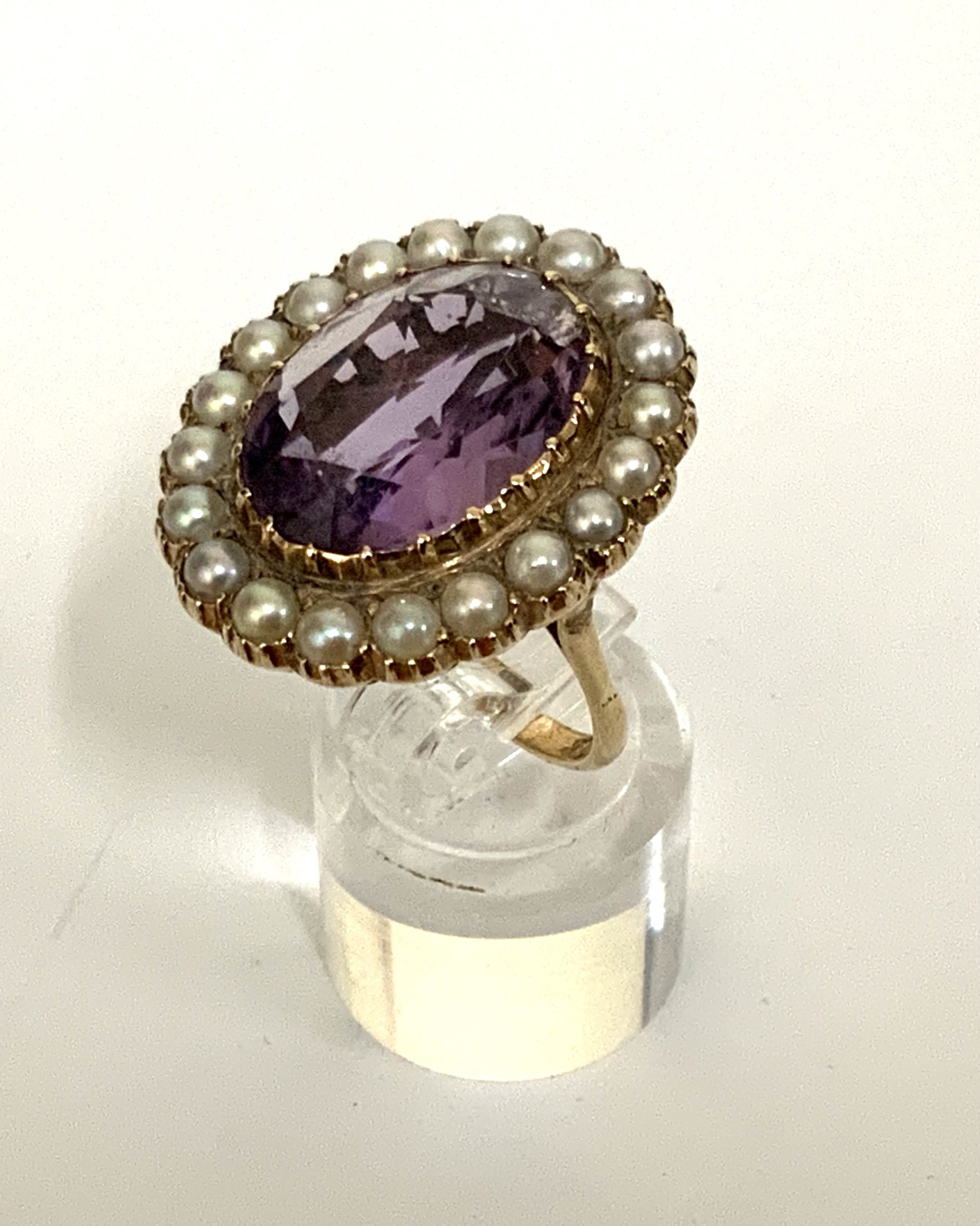 A 9ct gold dress ring inset with a large amethyst surrounded by seed pearls. (A)
