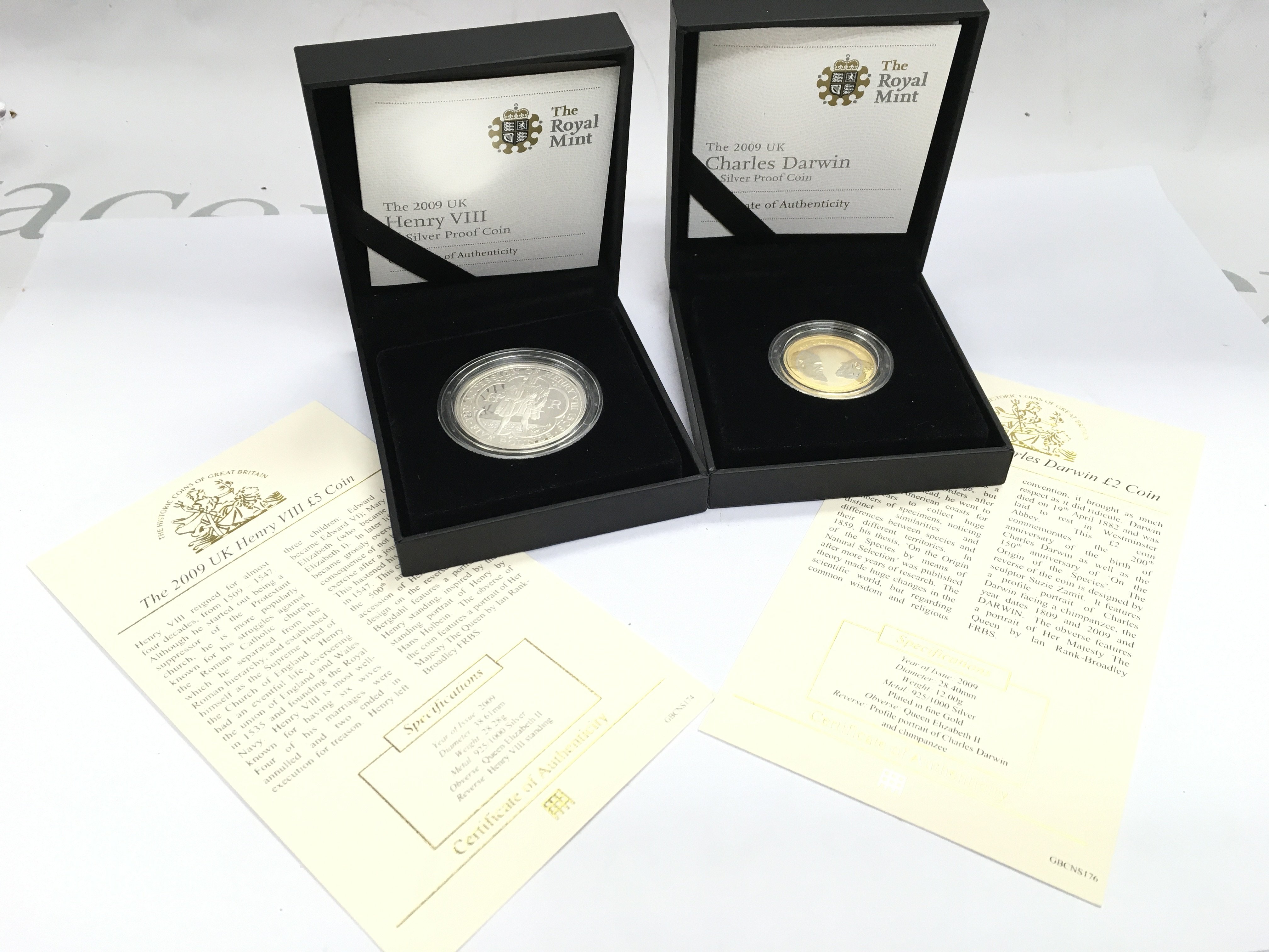 Cased Royal Mint Henry VII 2009 and Charles Darwin silver proof coins. Postage cat A