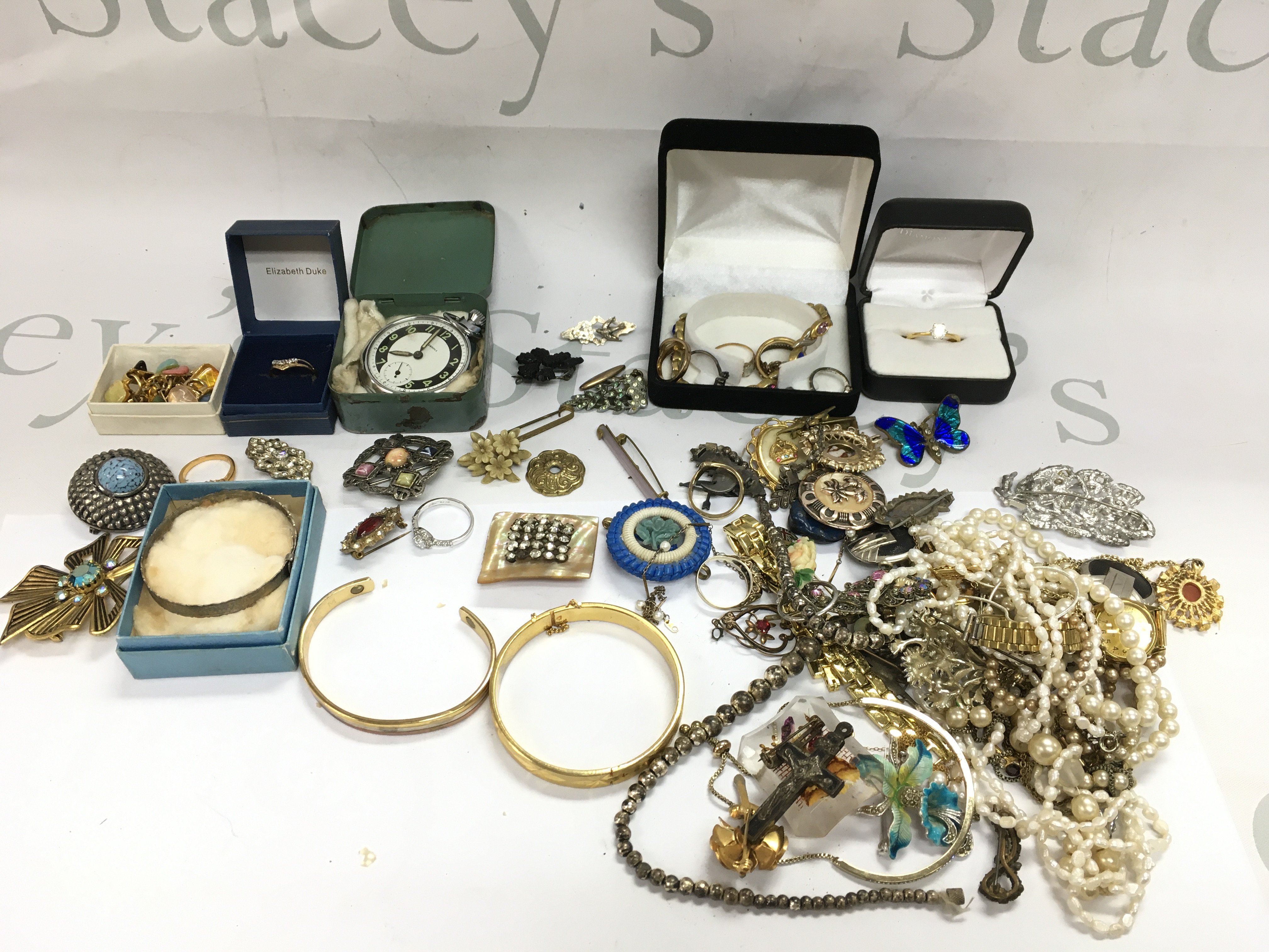 A collection of costume jewellery including some Silver, brooches, necklaces, rings , a 9 carat gold ring (1.3g), small 9ct necklace with a pearl pendant , Ingersoll pocket watch etc. Postage category B