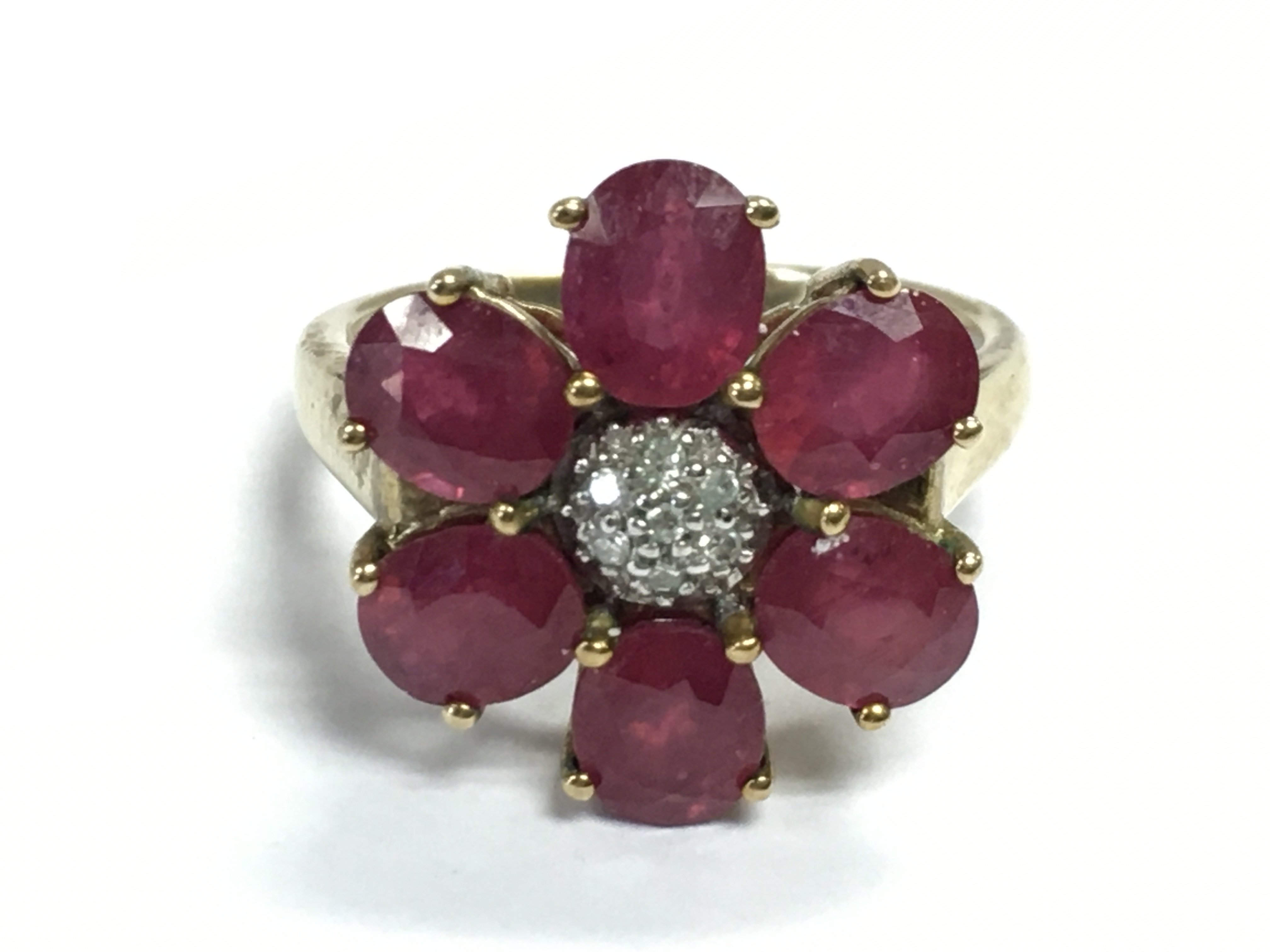 A 9ct gold ruby and diamond shard flower ring , 4.8g total weight. Postage Category A