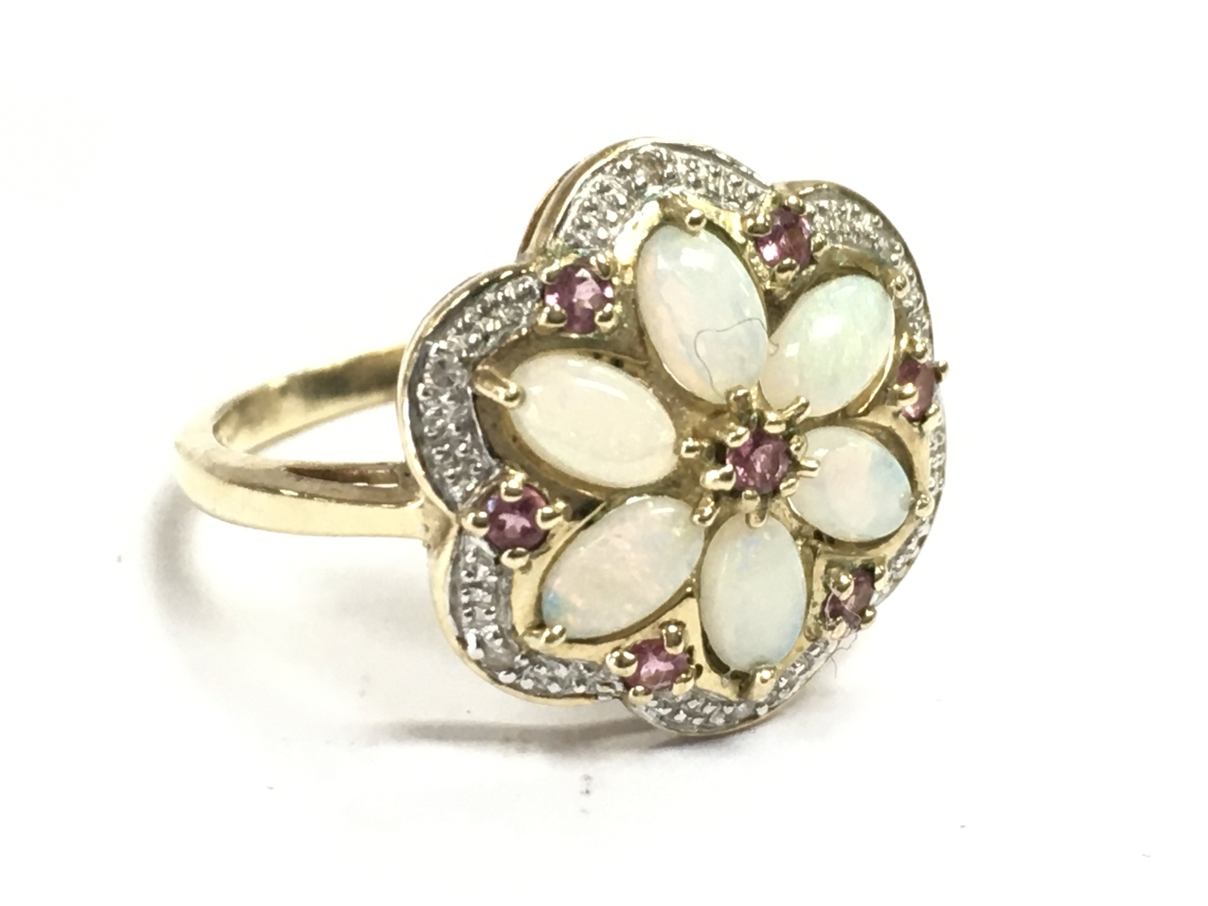 A 9 carat gold opal & ruby floral ring, size P. 3.8g total weight. Postage category A