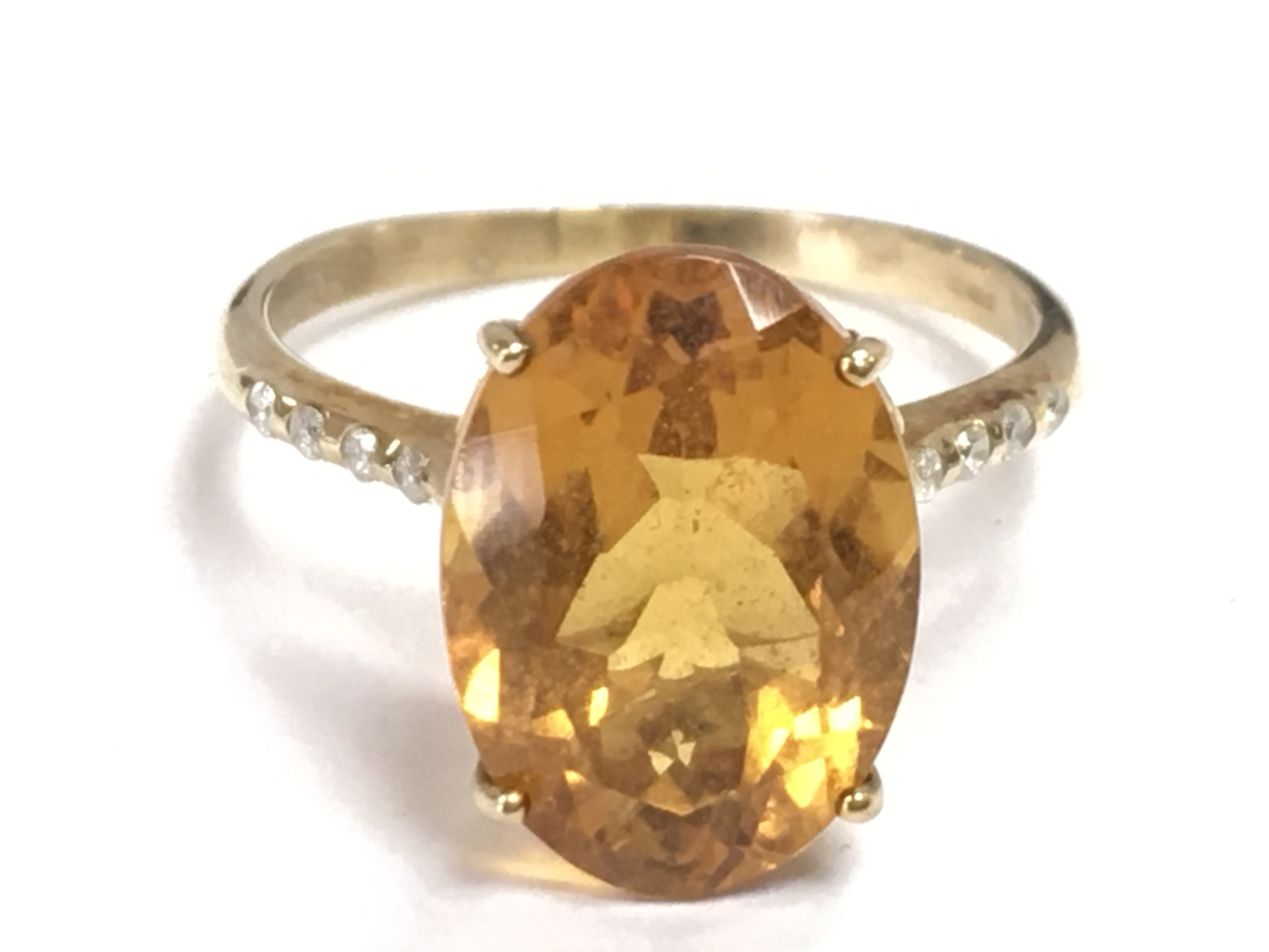 A 9 carat gold solitaire citrine set with small diamond stones, size Q. 3.4g total weight Postage category A