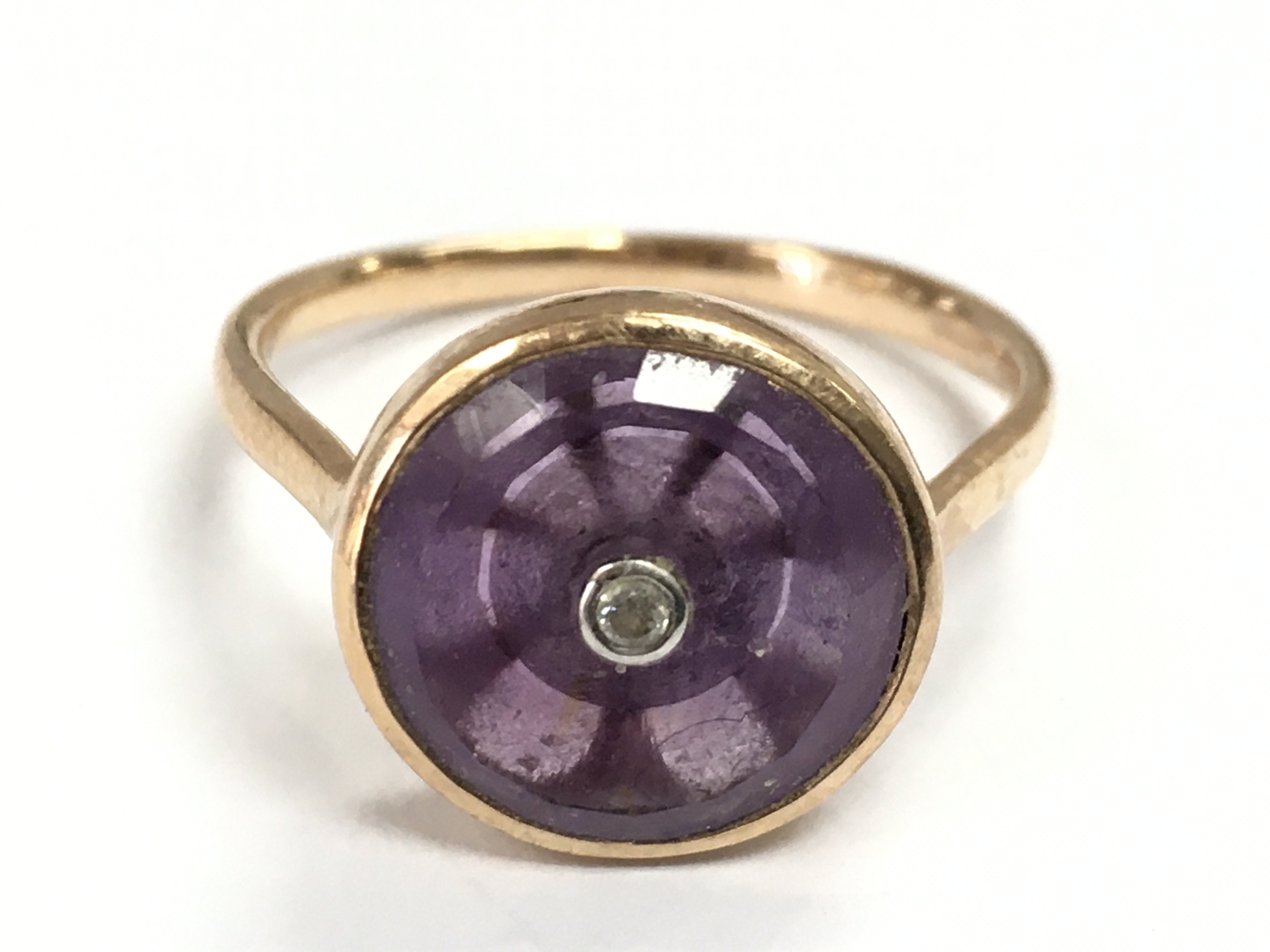 A 9 carat gold Amethyst with a single diamond stone ring, size S. 3.5g total weight. postage category A