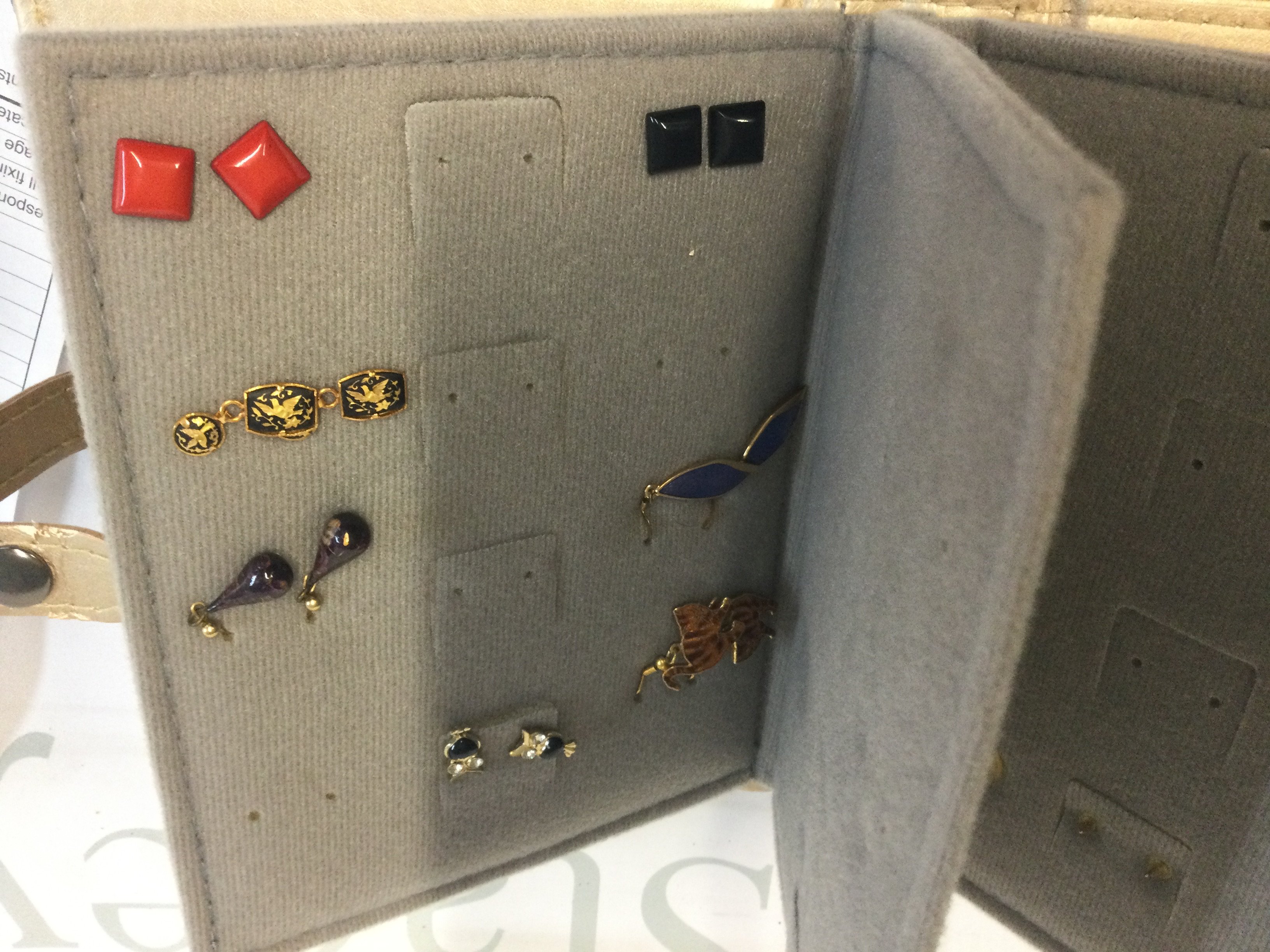 A folder containing various earrings.