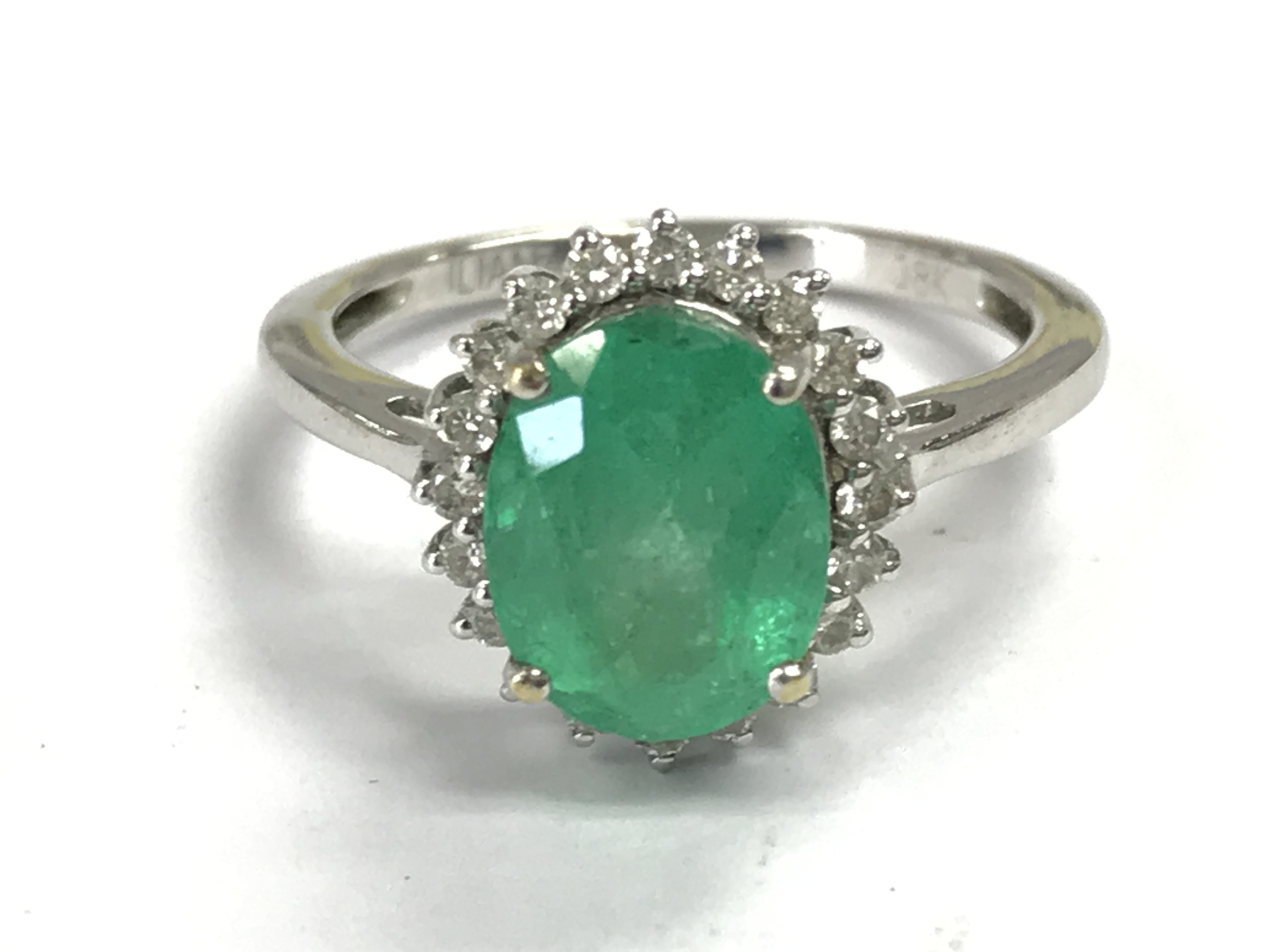 An 18 carat white gold diamond shard and emerald ring , 3.9 g. Size O/P. Postage category A
