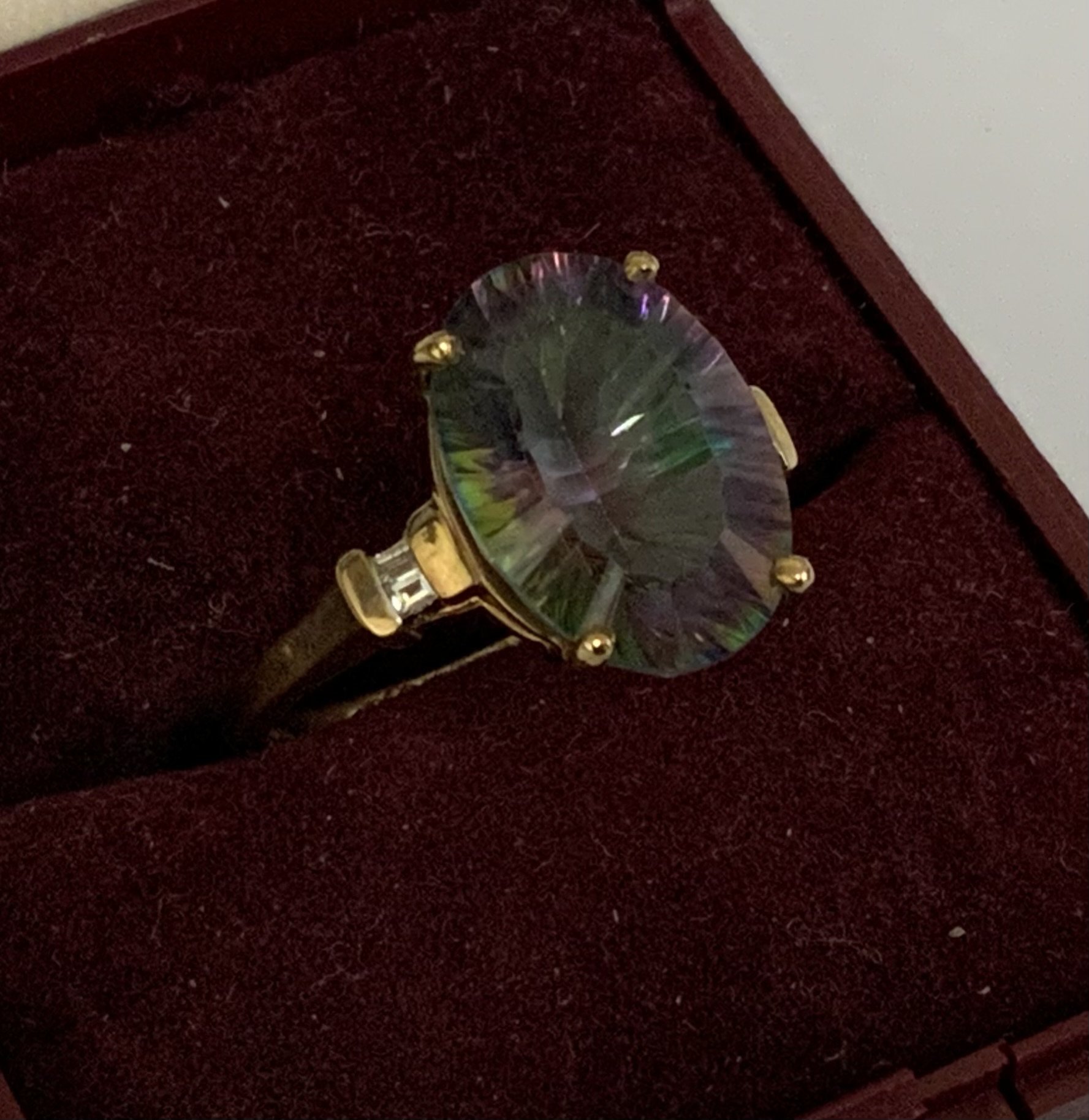 A 9ct gold ring set with a large mystic topaz and surmounted with baguette cut diamonds to shoulders, Size N. (A)