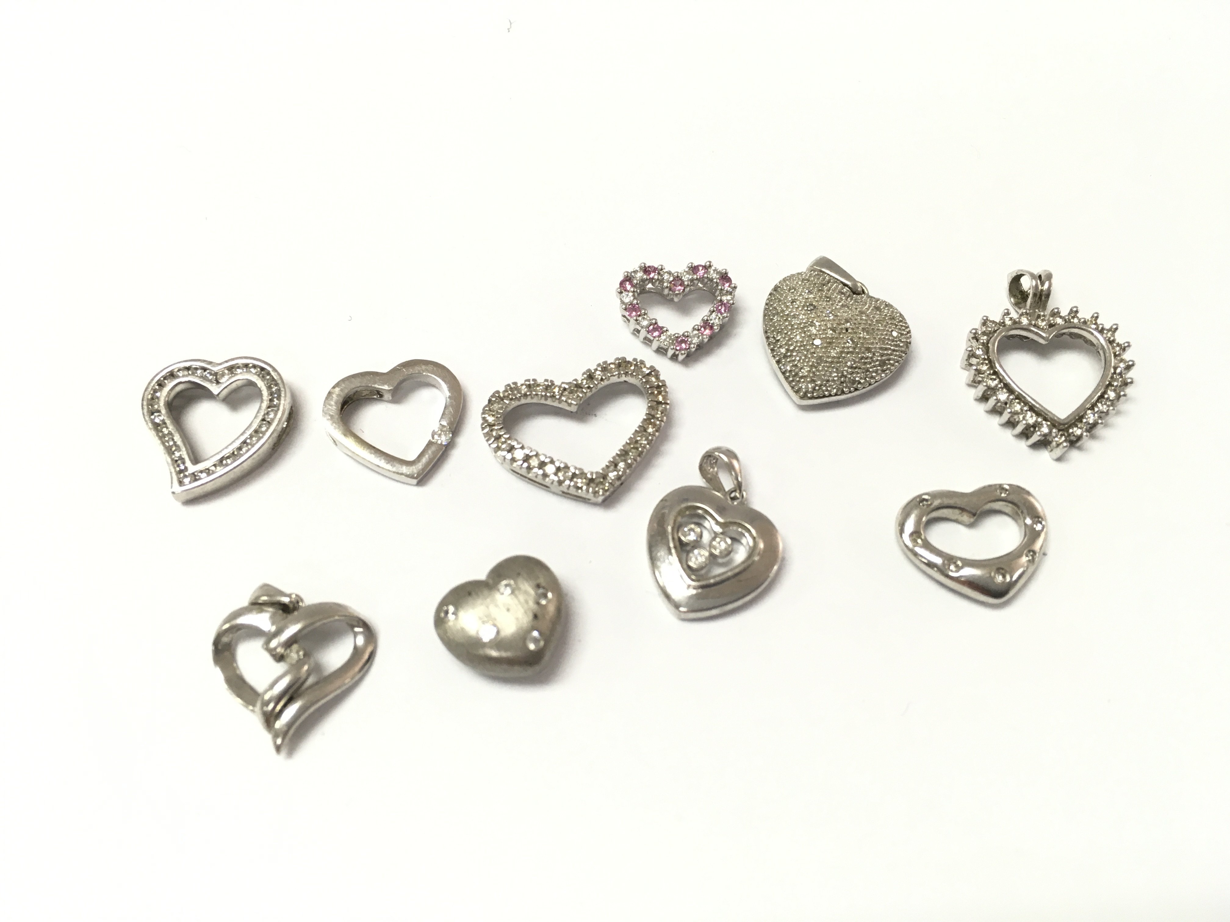 A collection of 9ct white gold heart diamond pendants including one which is CZ. 16.22g