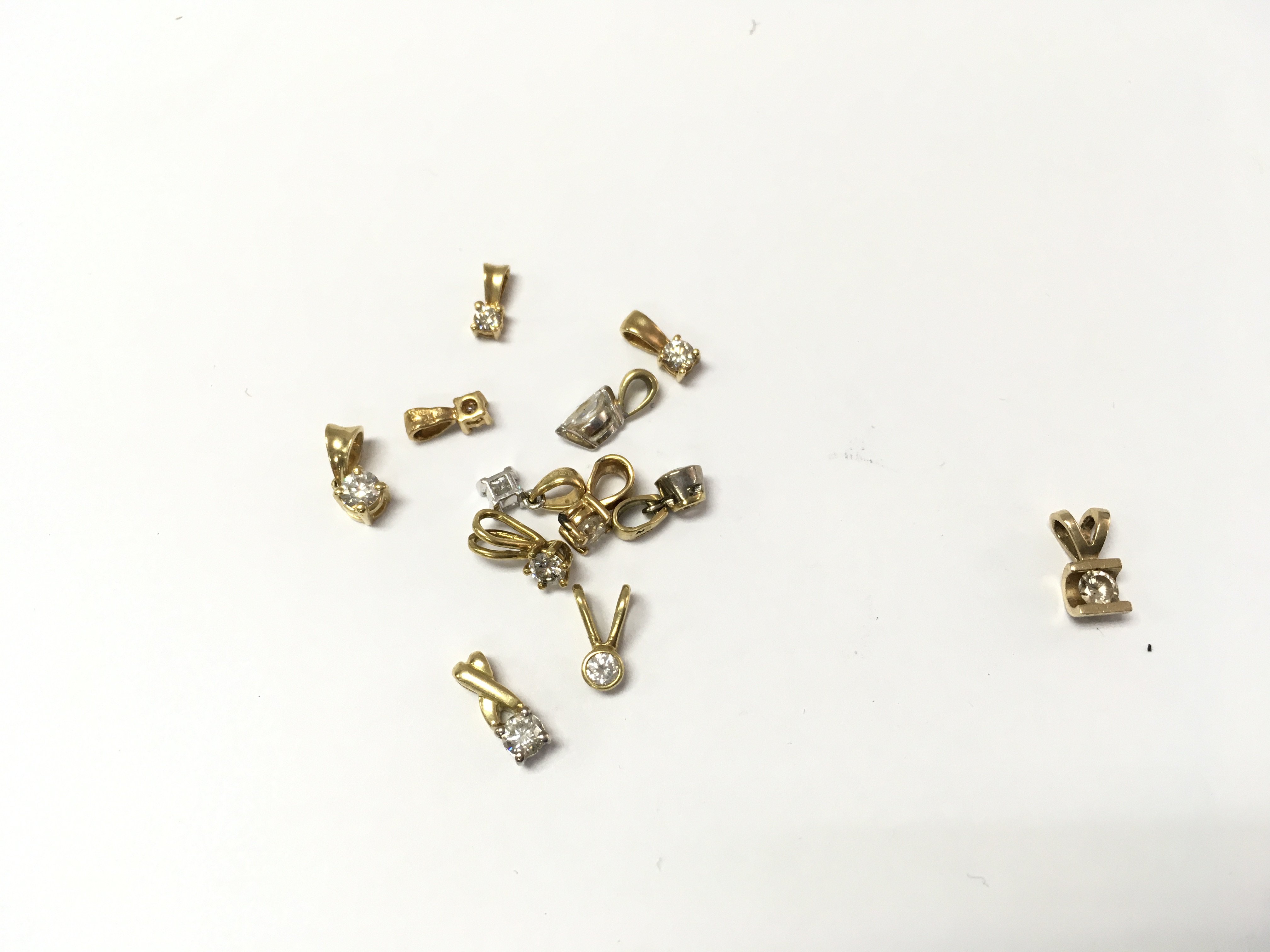 A collection of 18ct gold diamond pendants 5.75g and one 14ct gold pendant 0.75g