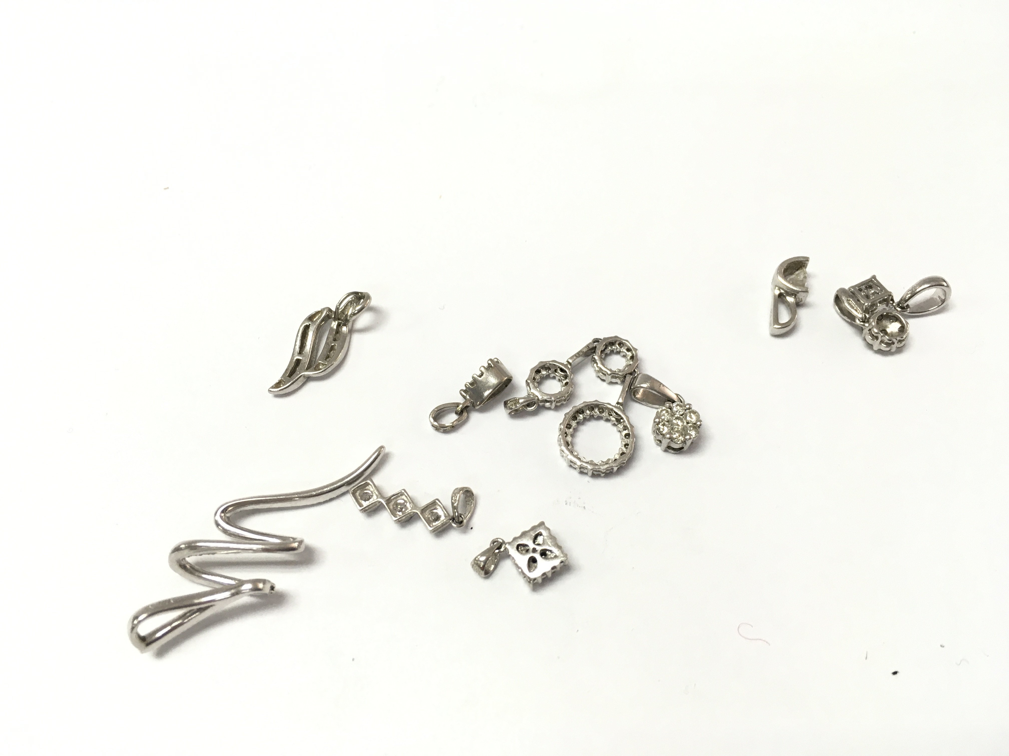 A collection of 9ct white gold diamond pendants. 9.89g
