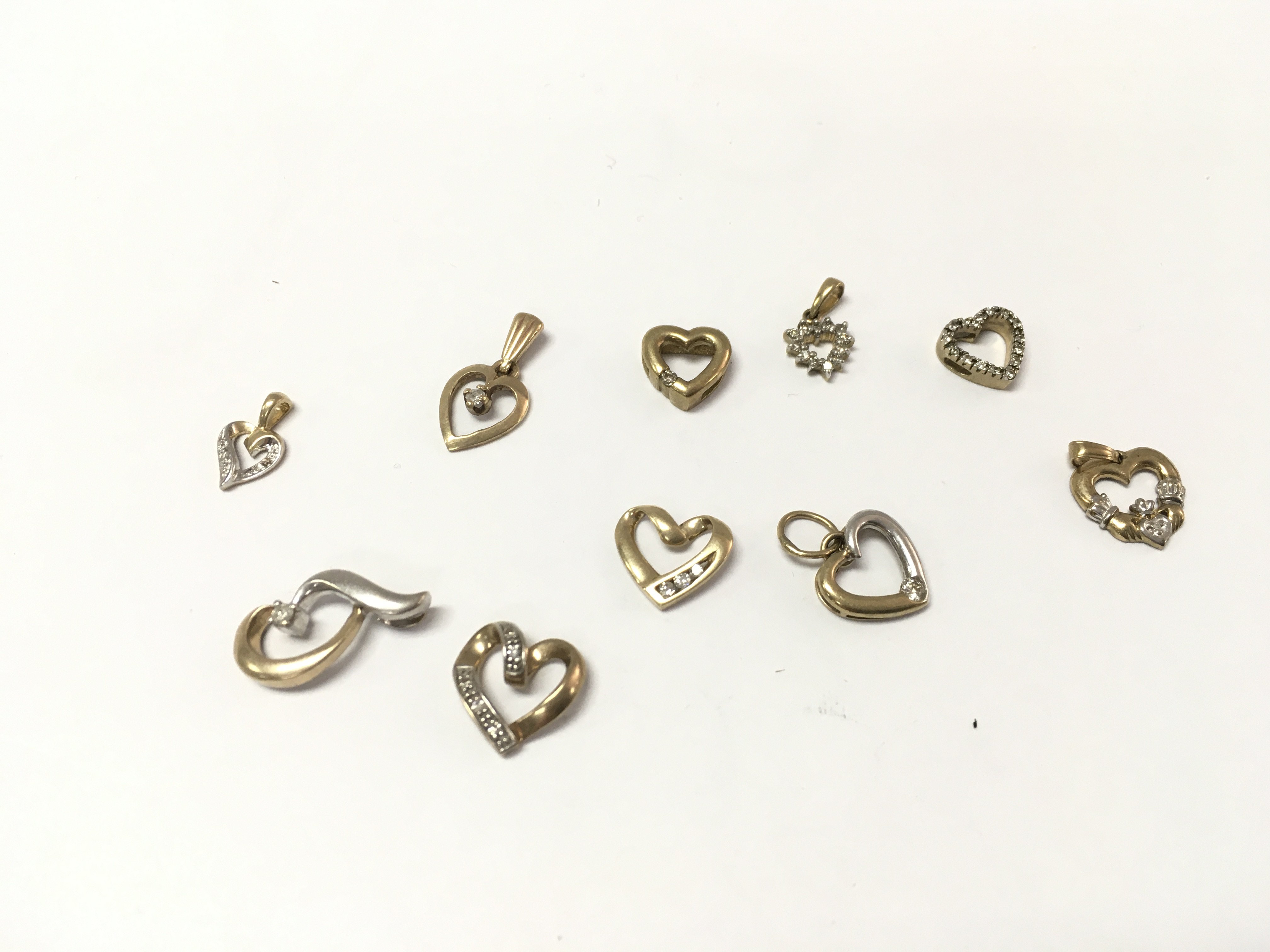 A collection of assorted 9ct gold heart pendants. 8.10g