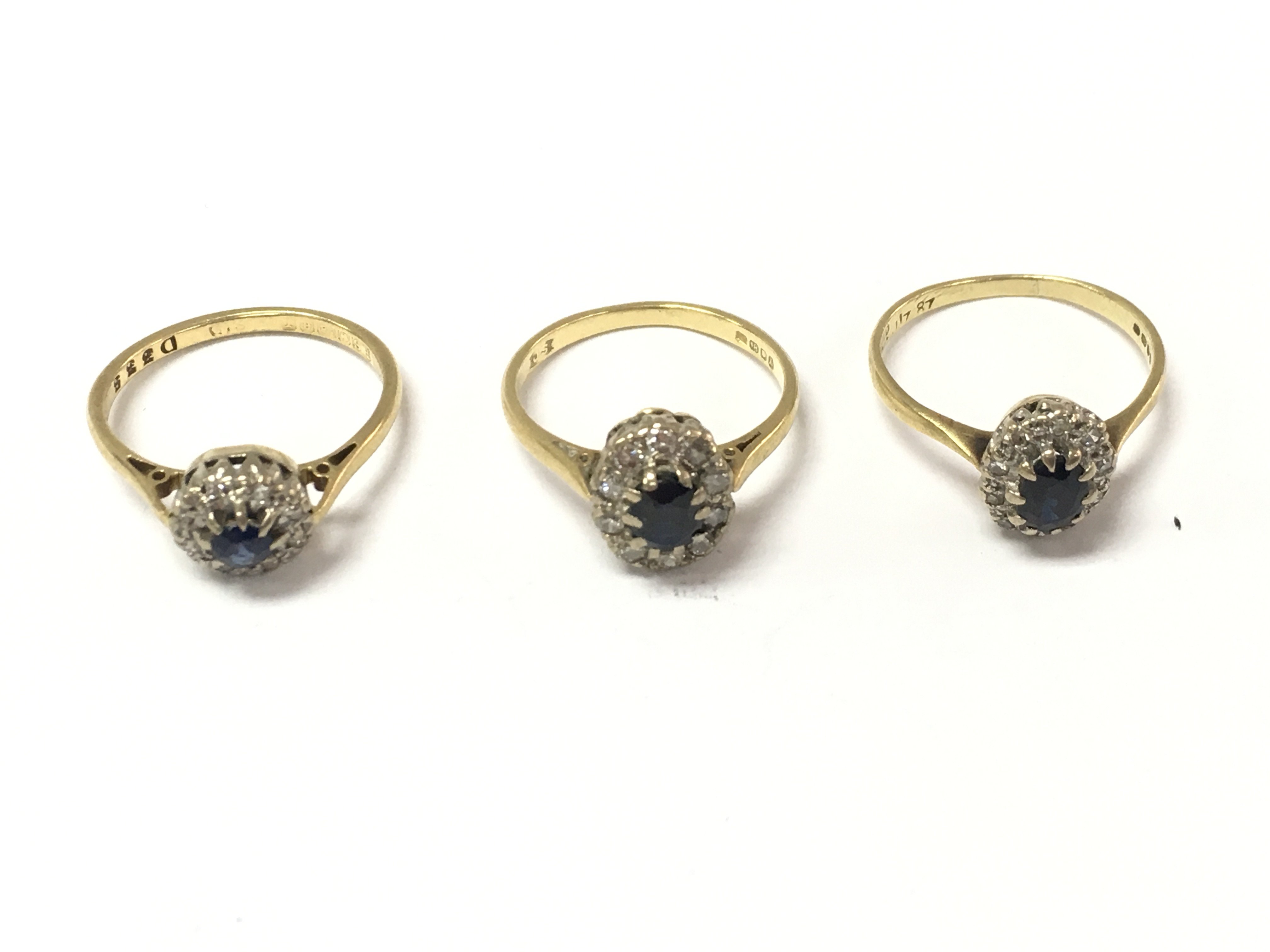 Three 18ct gold sapphire and diamond cluster rings. 8.25g