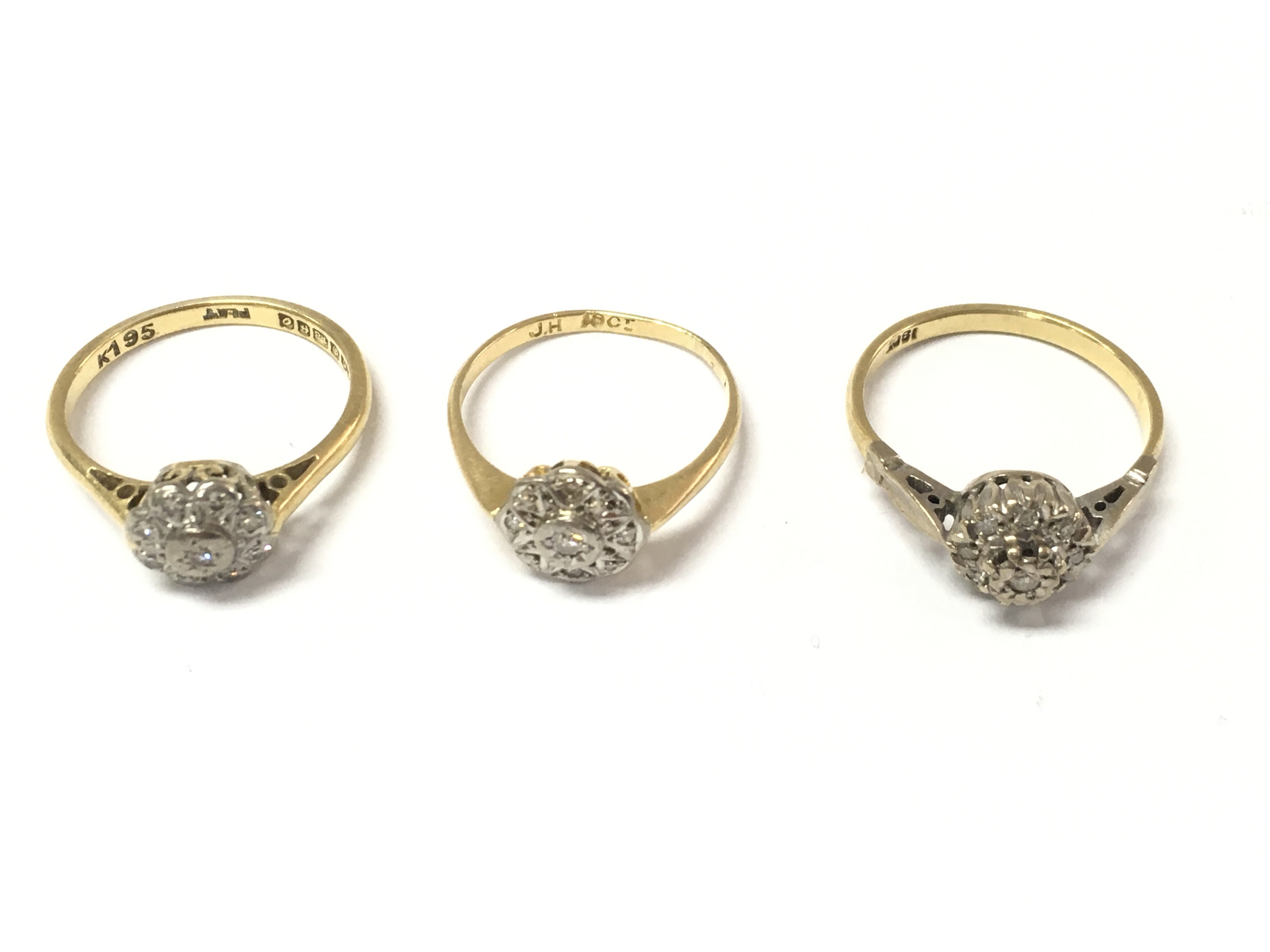 Three 18ct diamond cluster rings. 7.54g Postage A