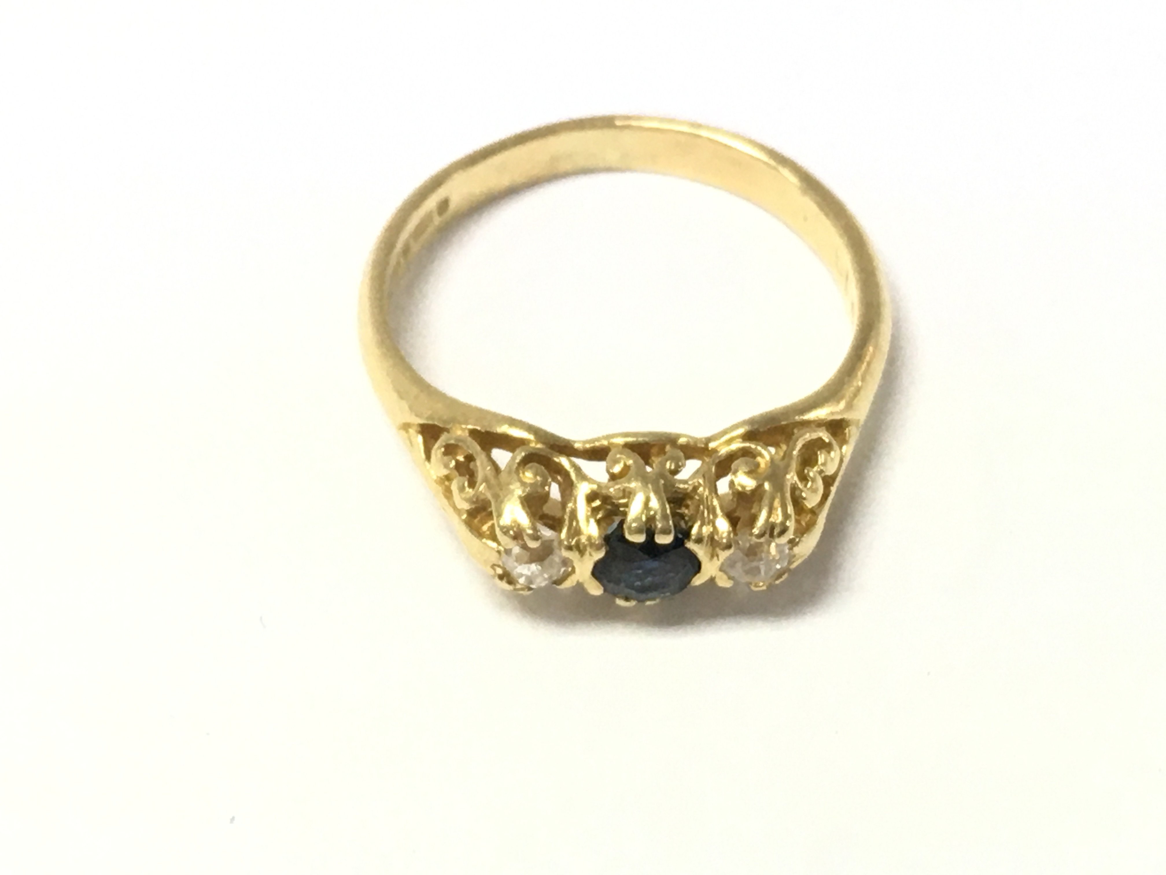 An 18ct gold sapphire and diamond three stone ring. Size L and 3.35g Postage A