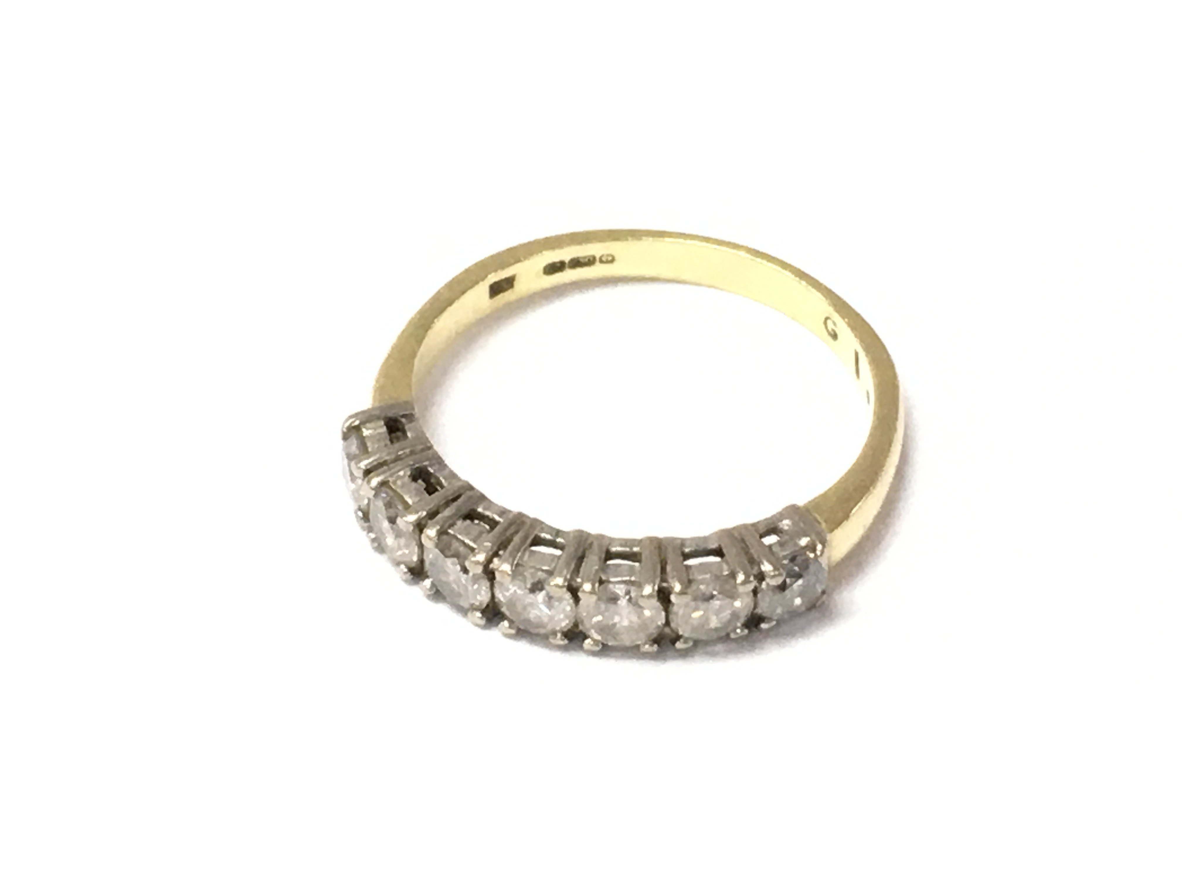 An 18ct gold diamond 7 stone ring. Size P and 3.35g Postage A