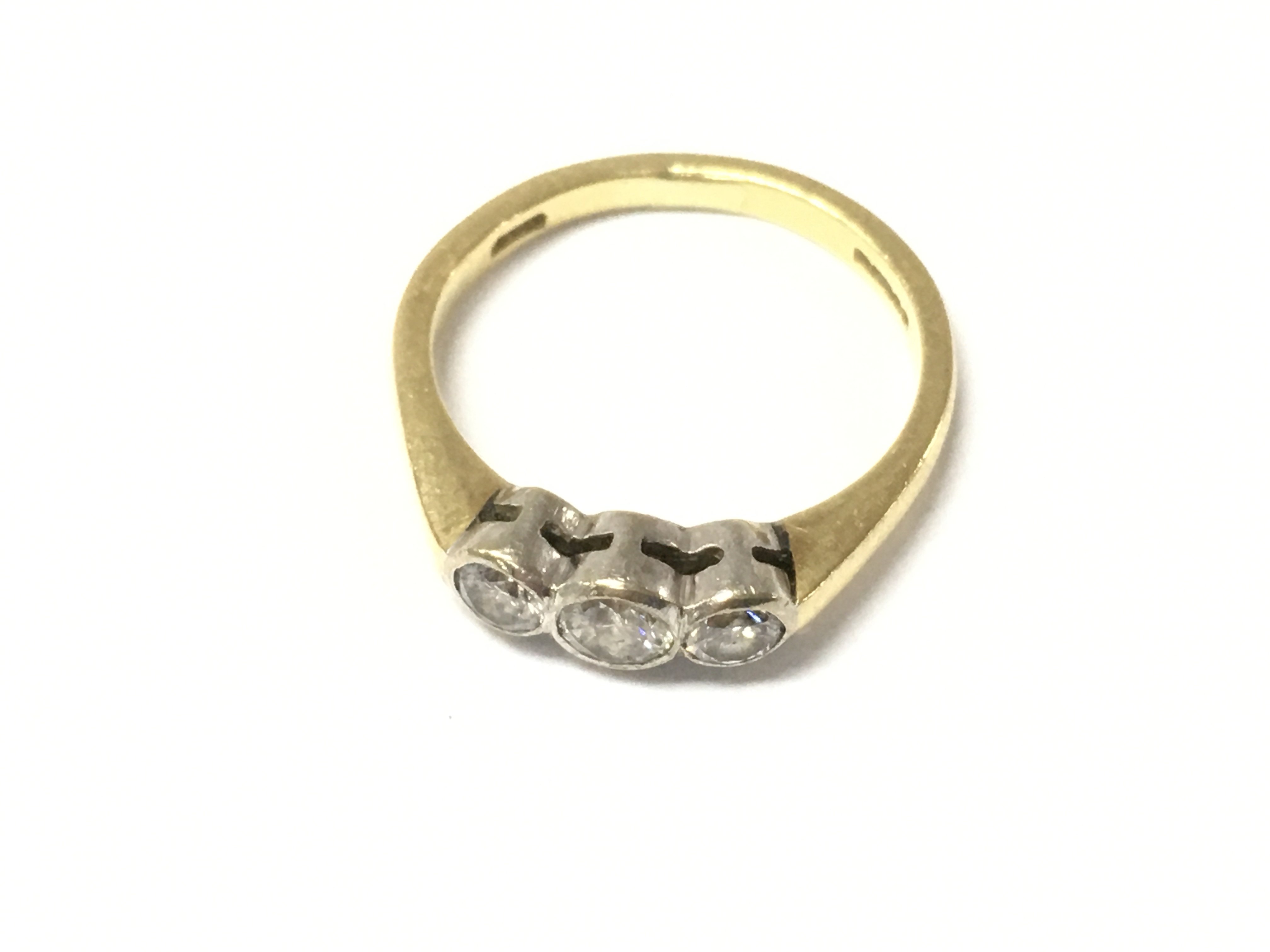 An 18ct gold three stone diamond ring. Size M and 3.76g