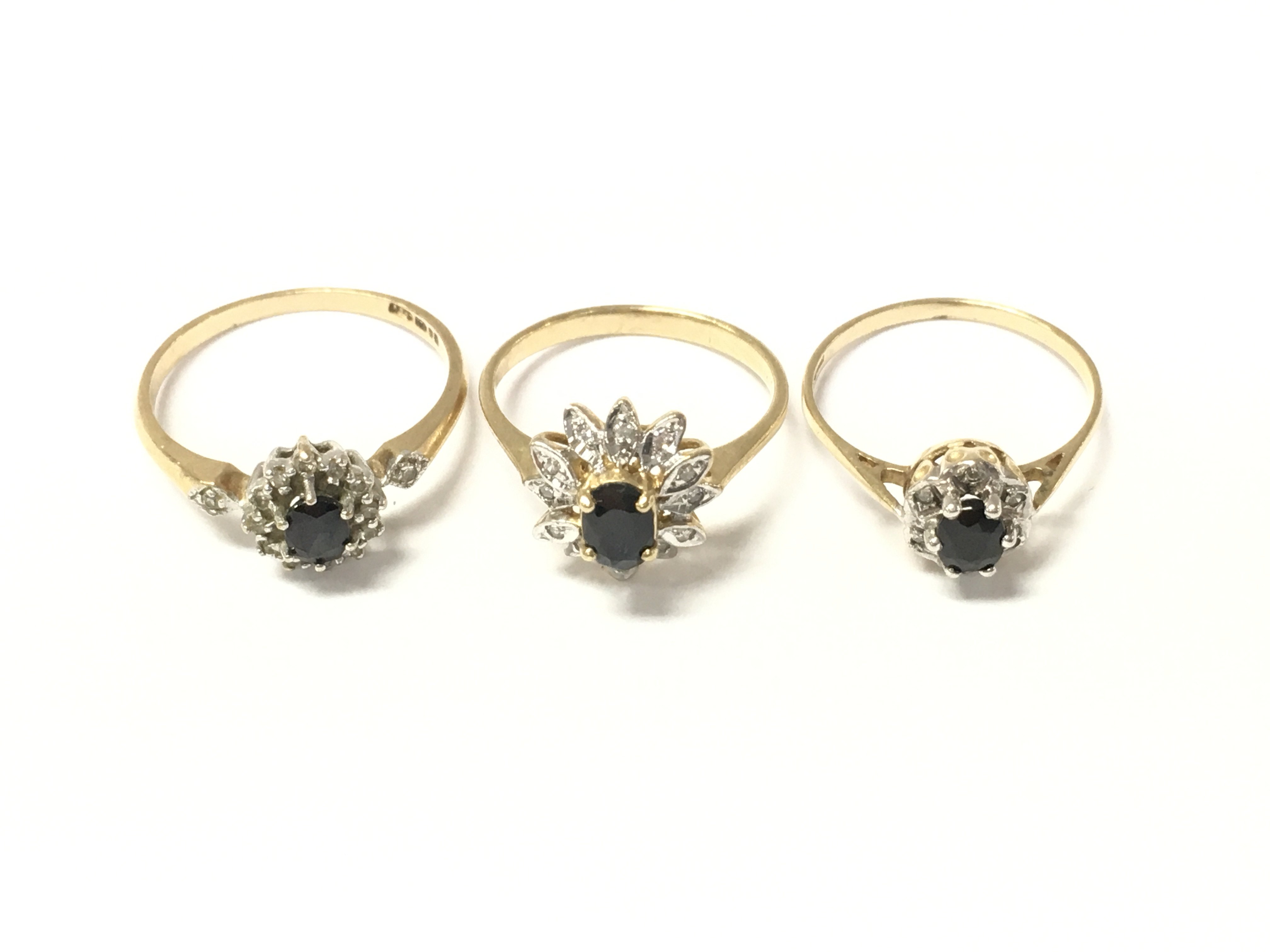 Three 9ct gold sapphire and diamond cluster rings. 5.73g