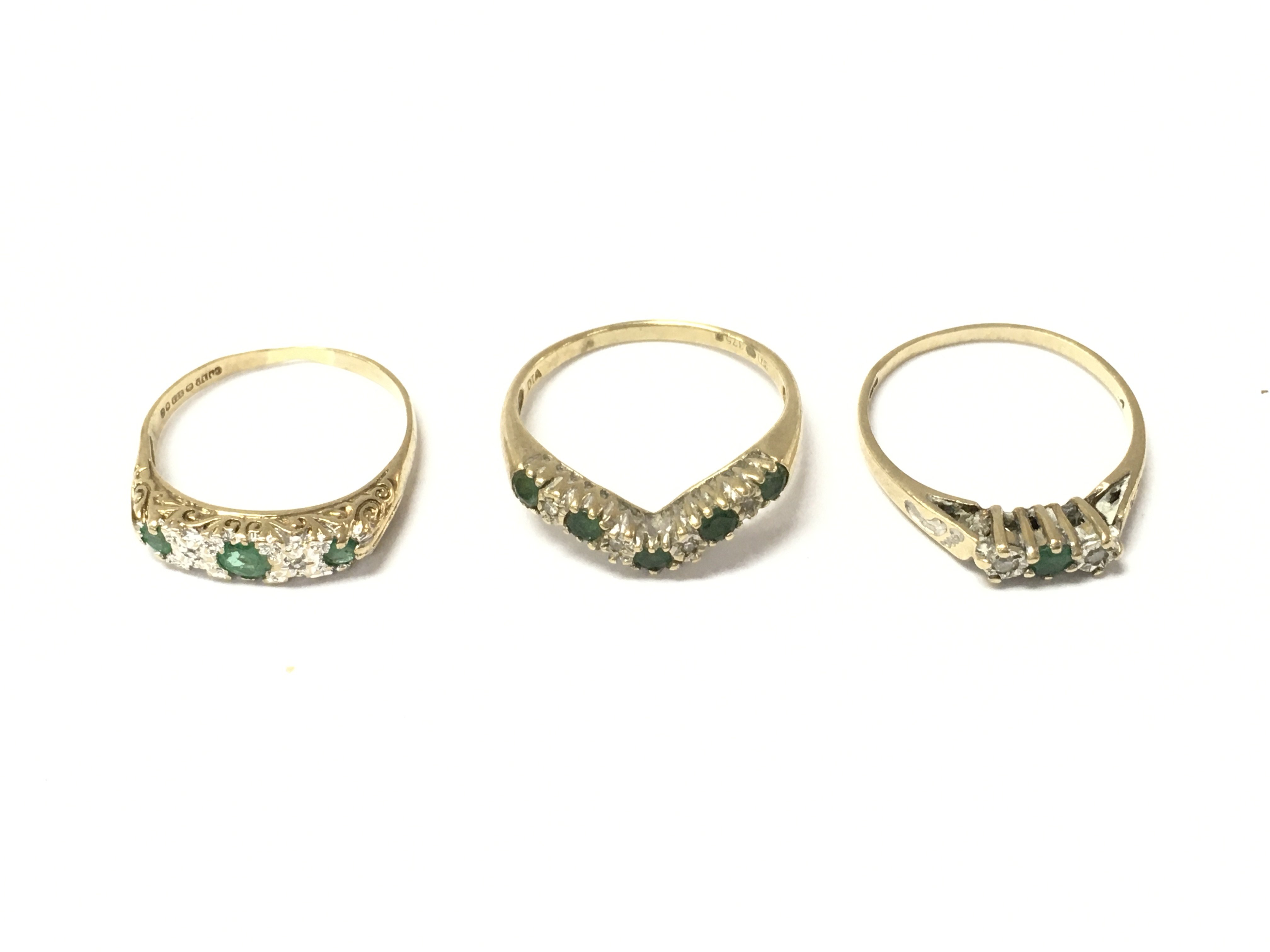 Three 9ct gold emerald and diamond rings. 5.43g Postage A