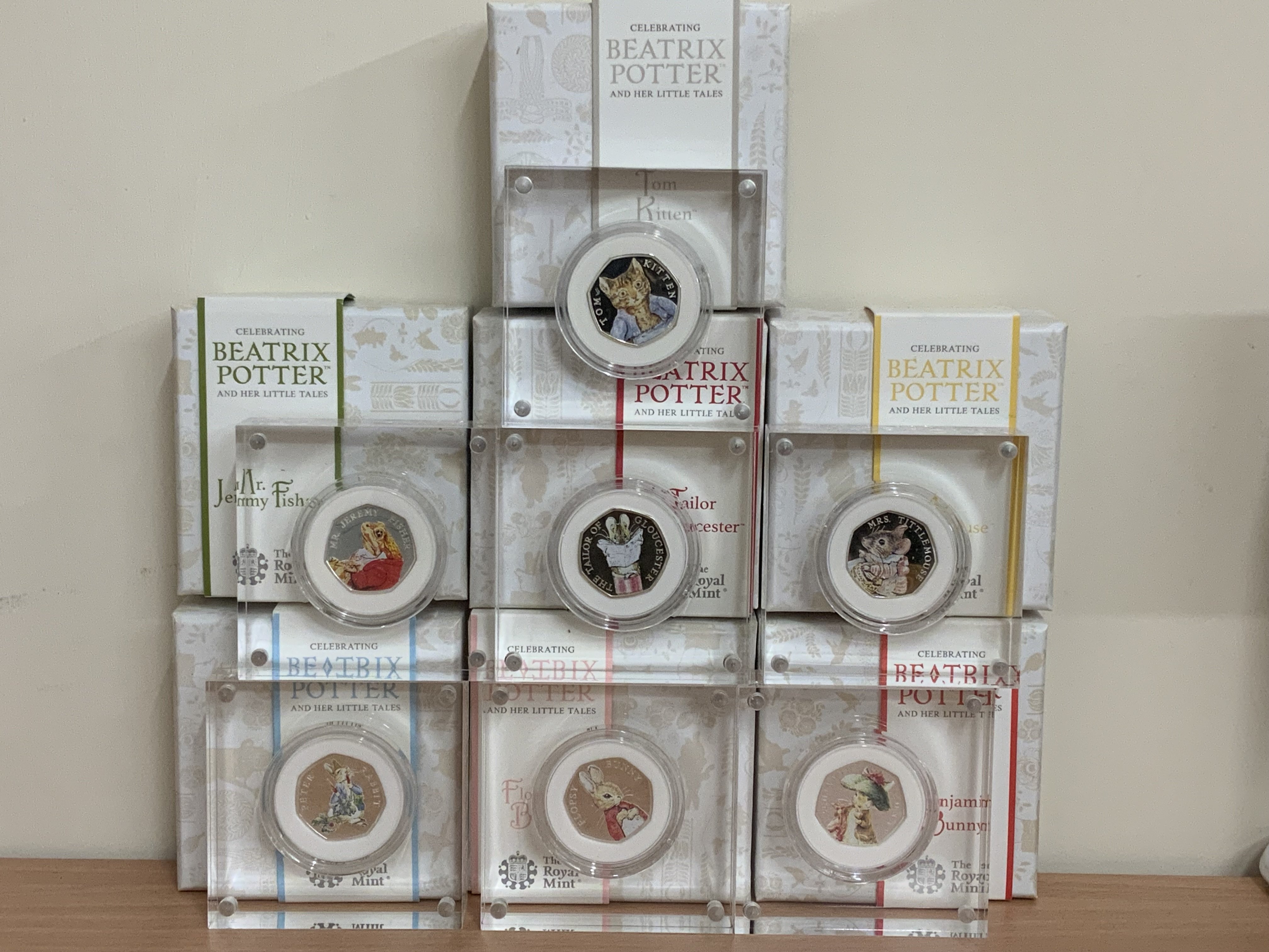 7 Royal Mint Beatrix Potter cased coloured silver 50p coins to include 2017 Tom Kitten, 2017 Jeremy Fisher, 2018 Peter Rabbit, 2018 The Tailor Gloucester, 2018 Flopsy Bunny, 2018 Mrs Tittlemouse, 2017 Benjamin Bunny. (B)