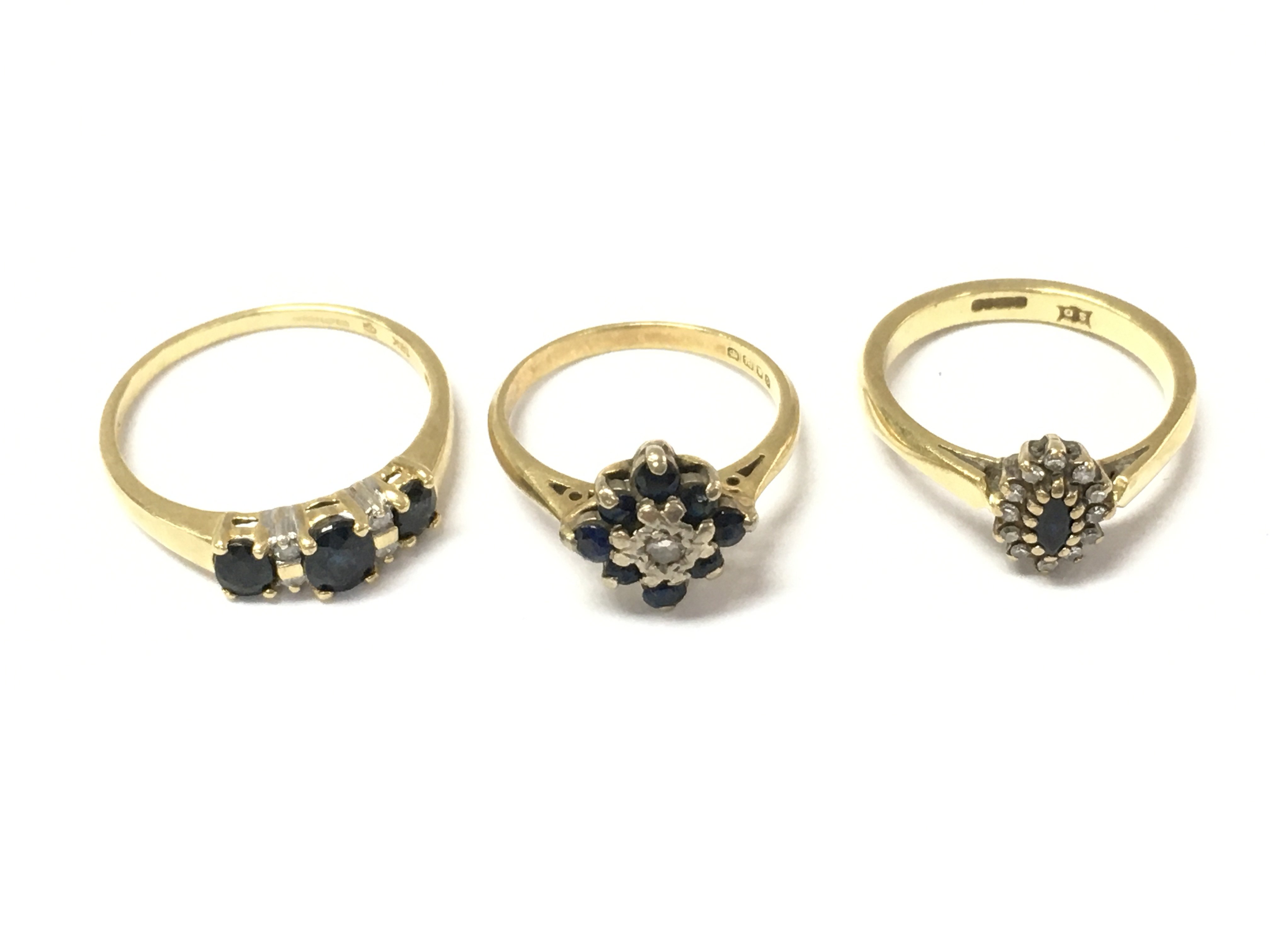 Three 18ct gold sapphire and diamond cluster rings. 8.25g