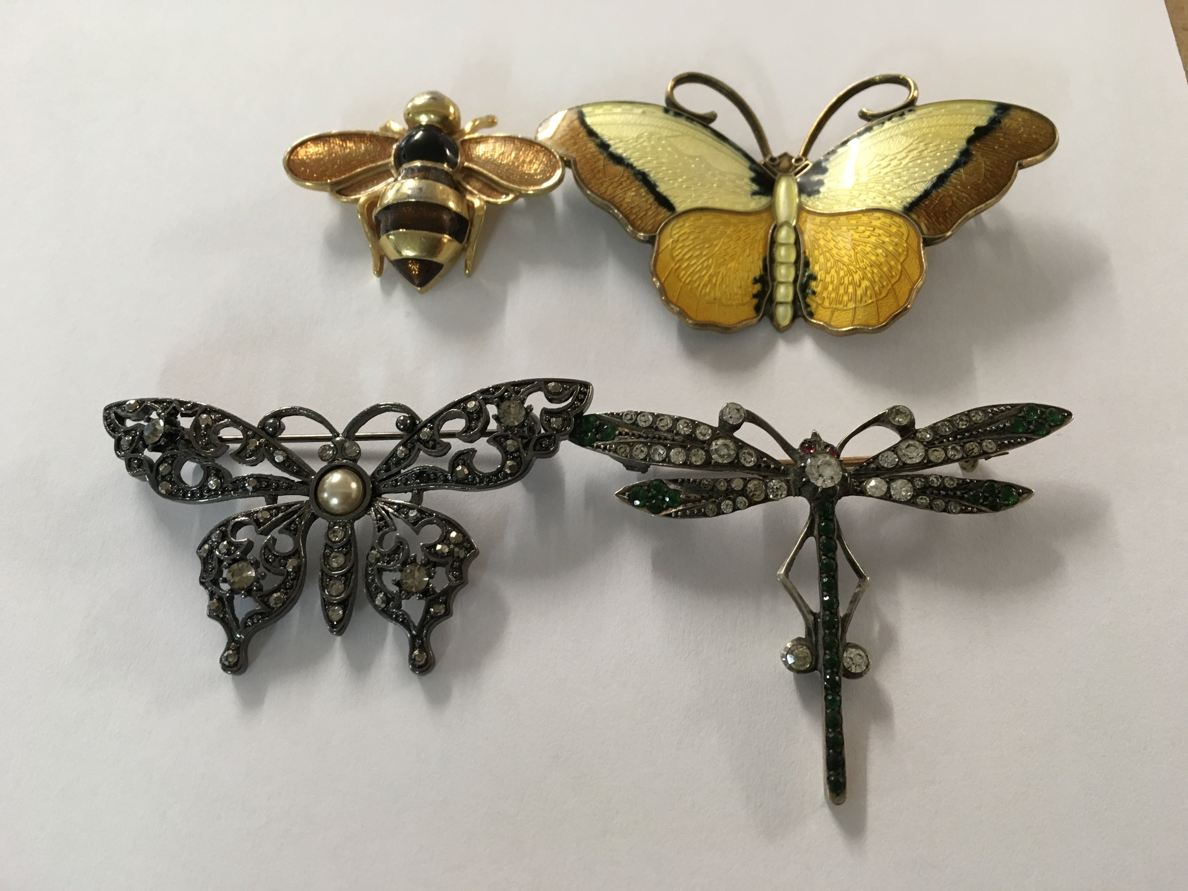 A collection of four butterflies and dragonflies brooches , including enamel .