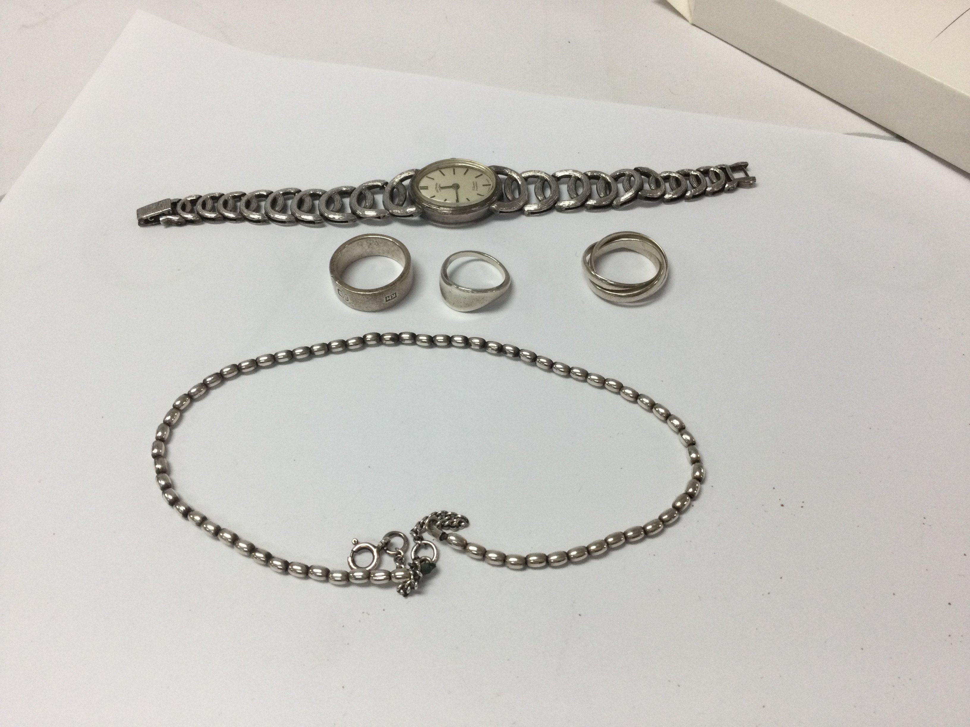 A collection of silver items including watche three rings and necklace.