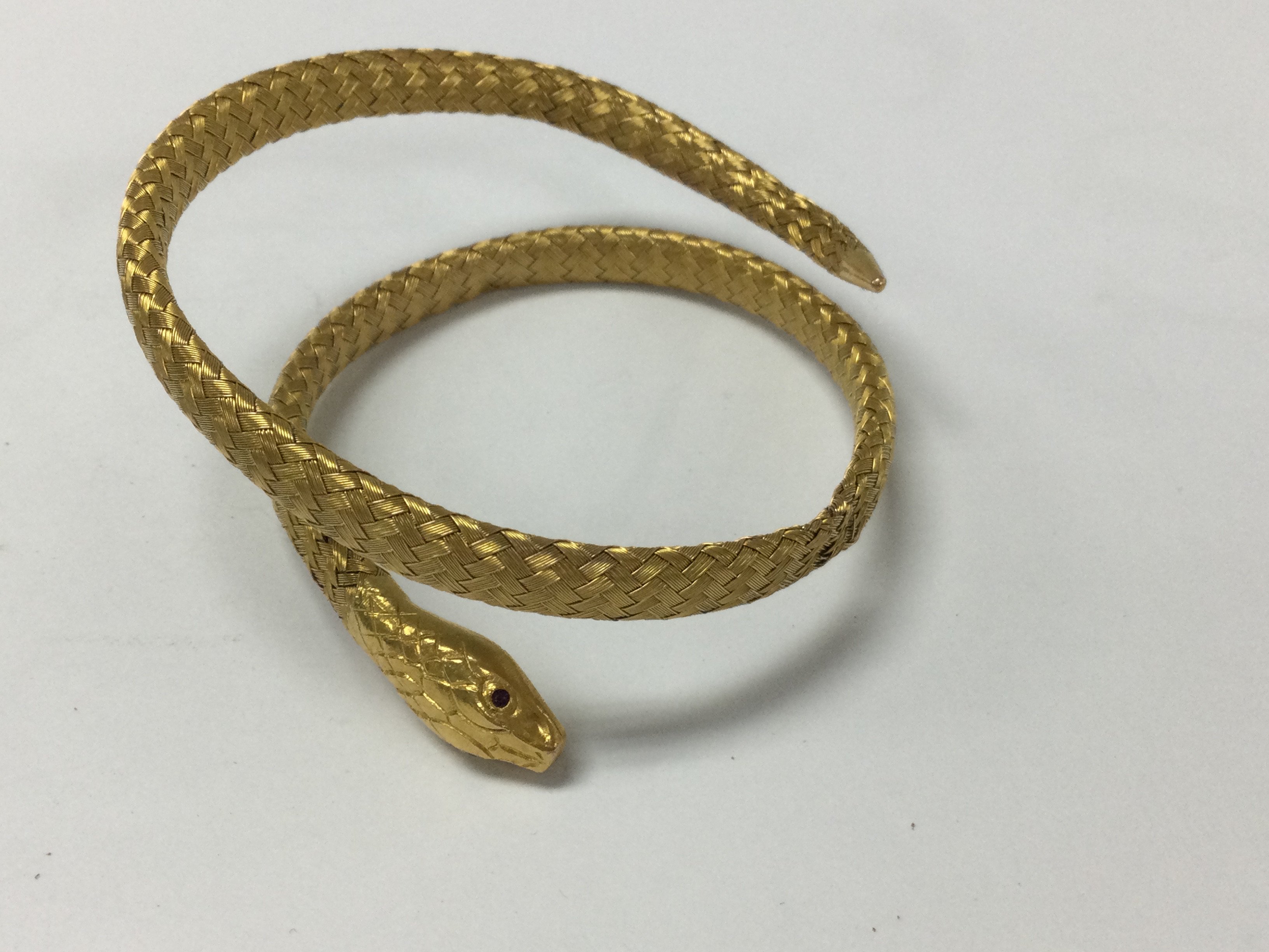 A gold bangle n the form of a serpent with rubie eyes .17 grams.