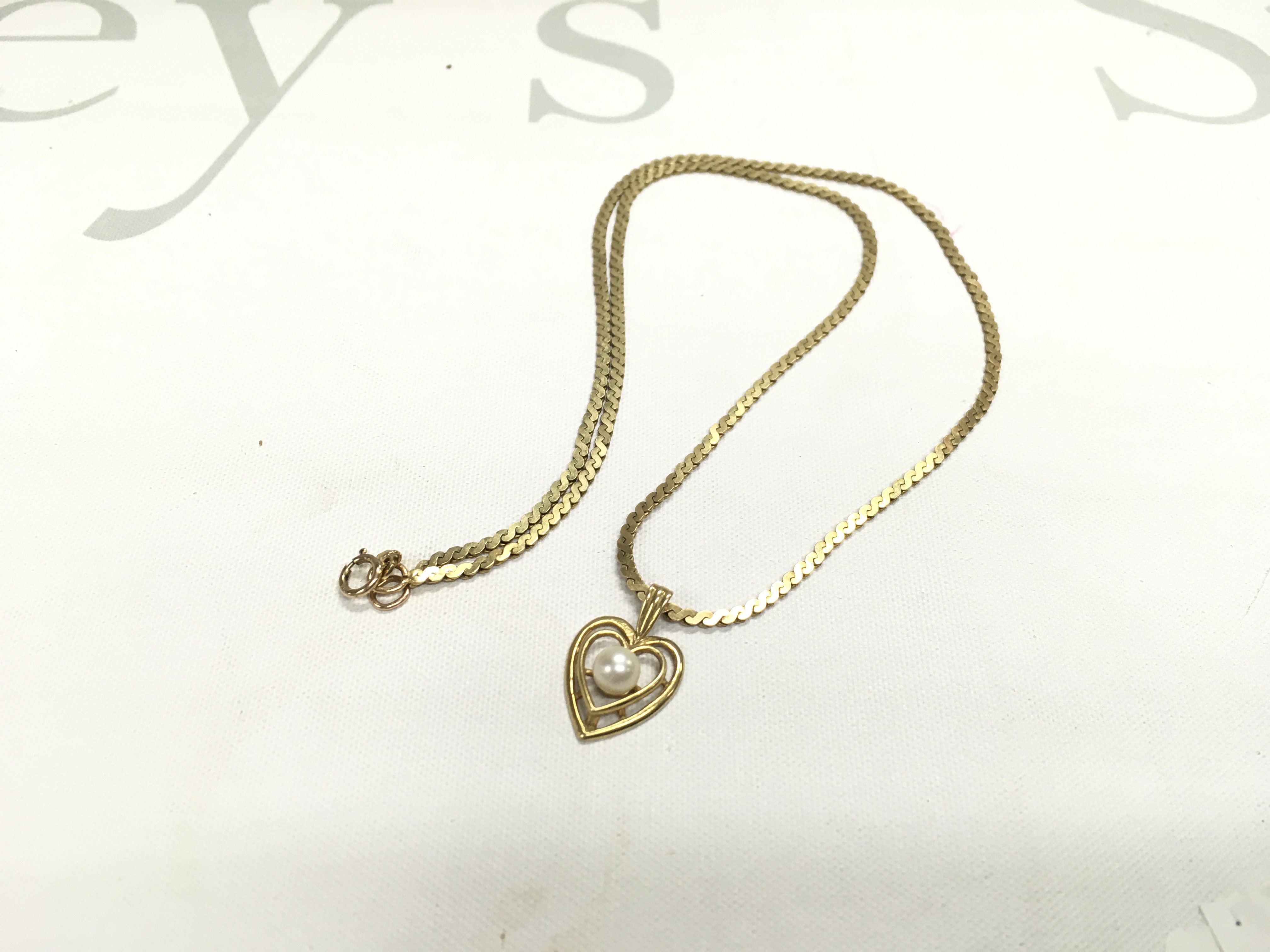 A 9ct gold S link chain with a heart pendant, approx weight 7.83 grams.