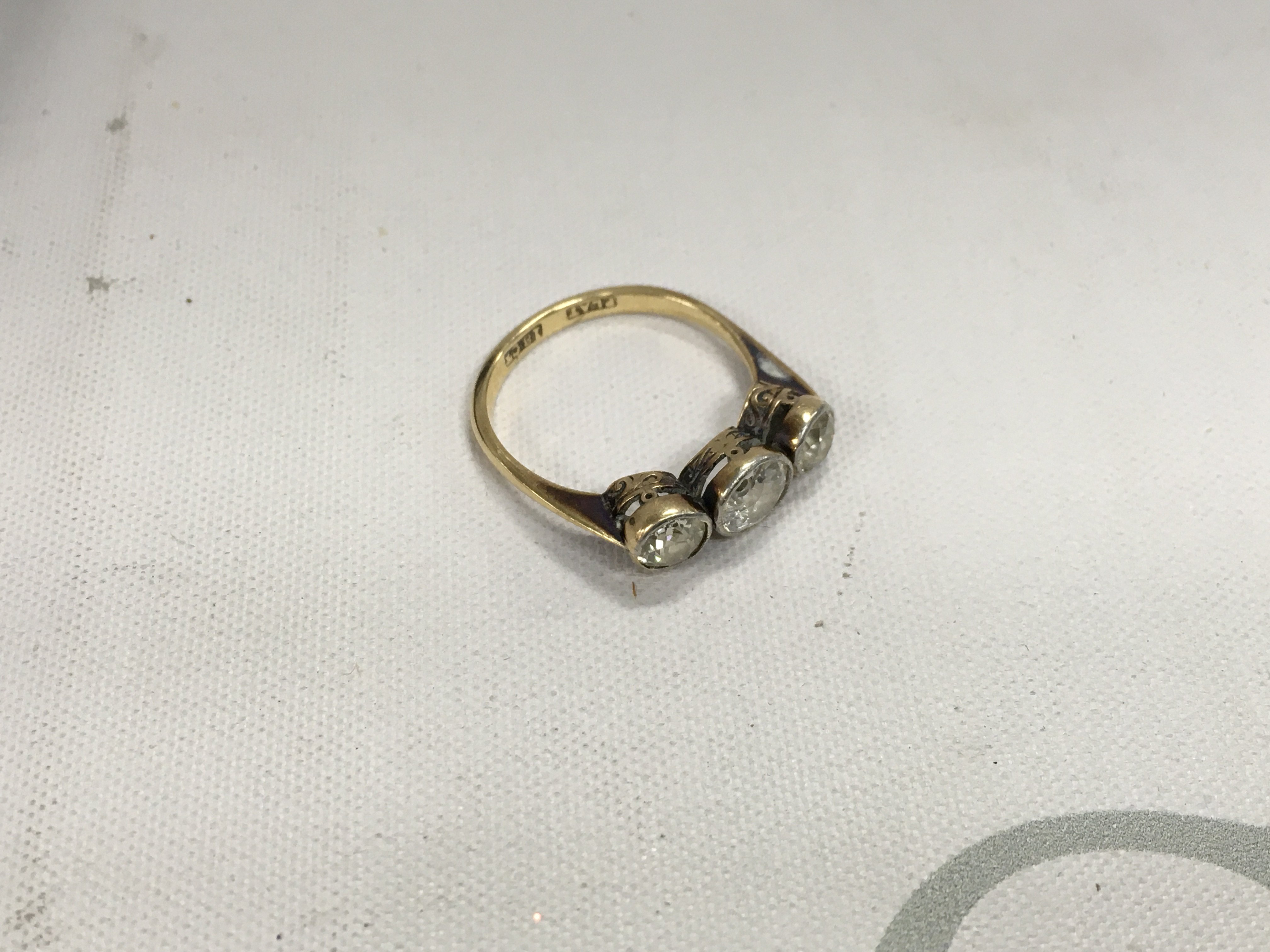 An 18ct gold and platinum three stone old cut diamond ring. Approx weight 2.95 grams, size N.