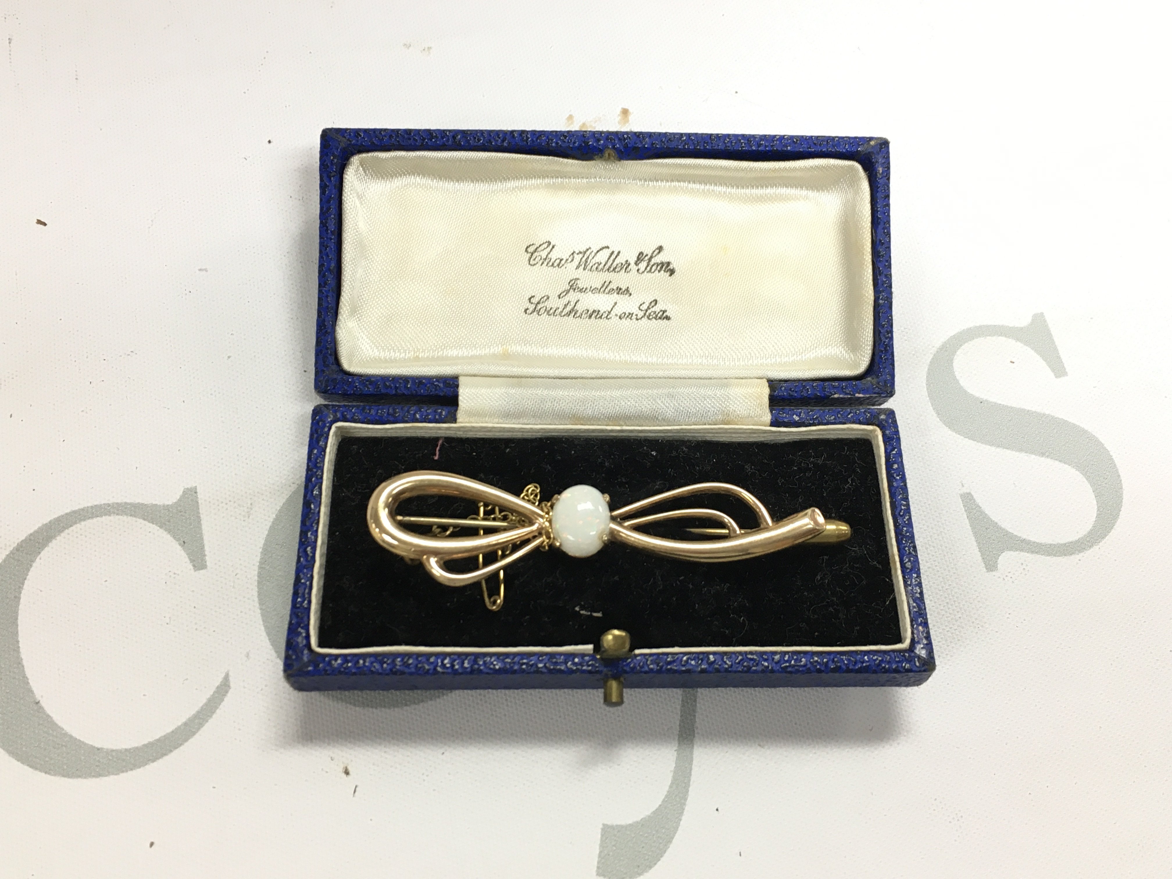 A 9ct gold bow shaped brooch set with an opal. Approx weight 5.50 grams.