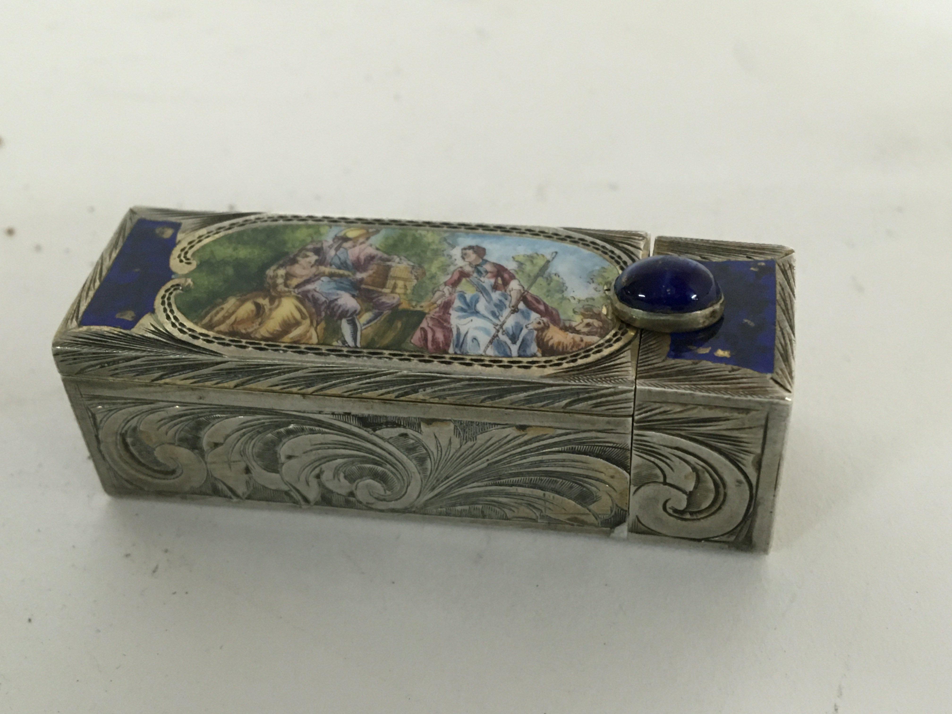 A Quality Continental silver (800) lipstick holder decorated with an enamel oval with figures and engraved silver parcel gilt interior with a spring loaded mirror. Length 6cm