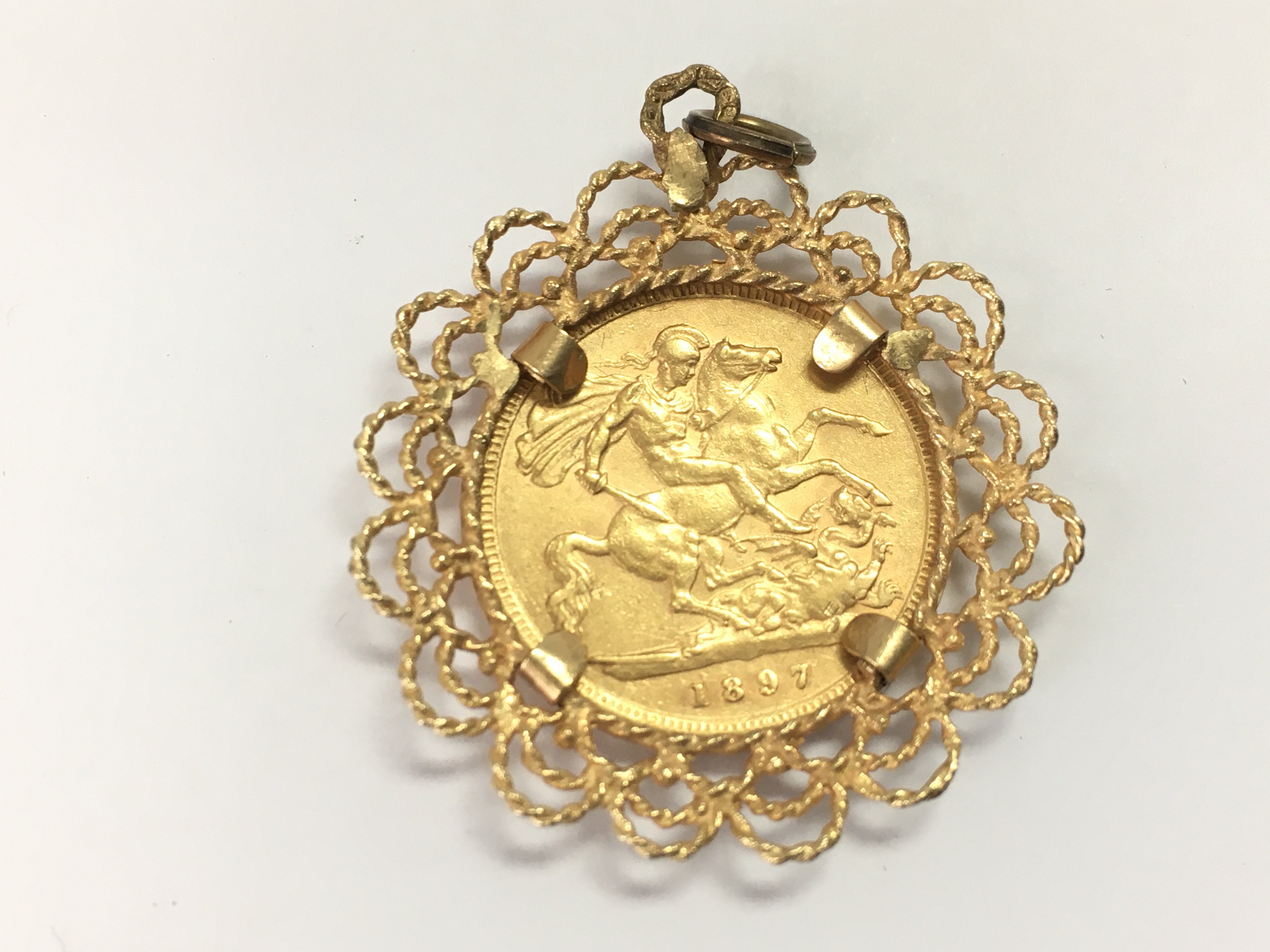 An 1897 half Sovereign in a 9ct gold mount. 6.24g Postage A