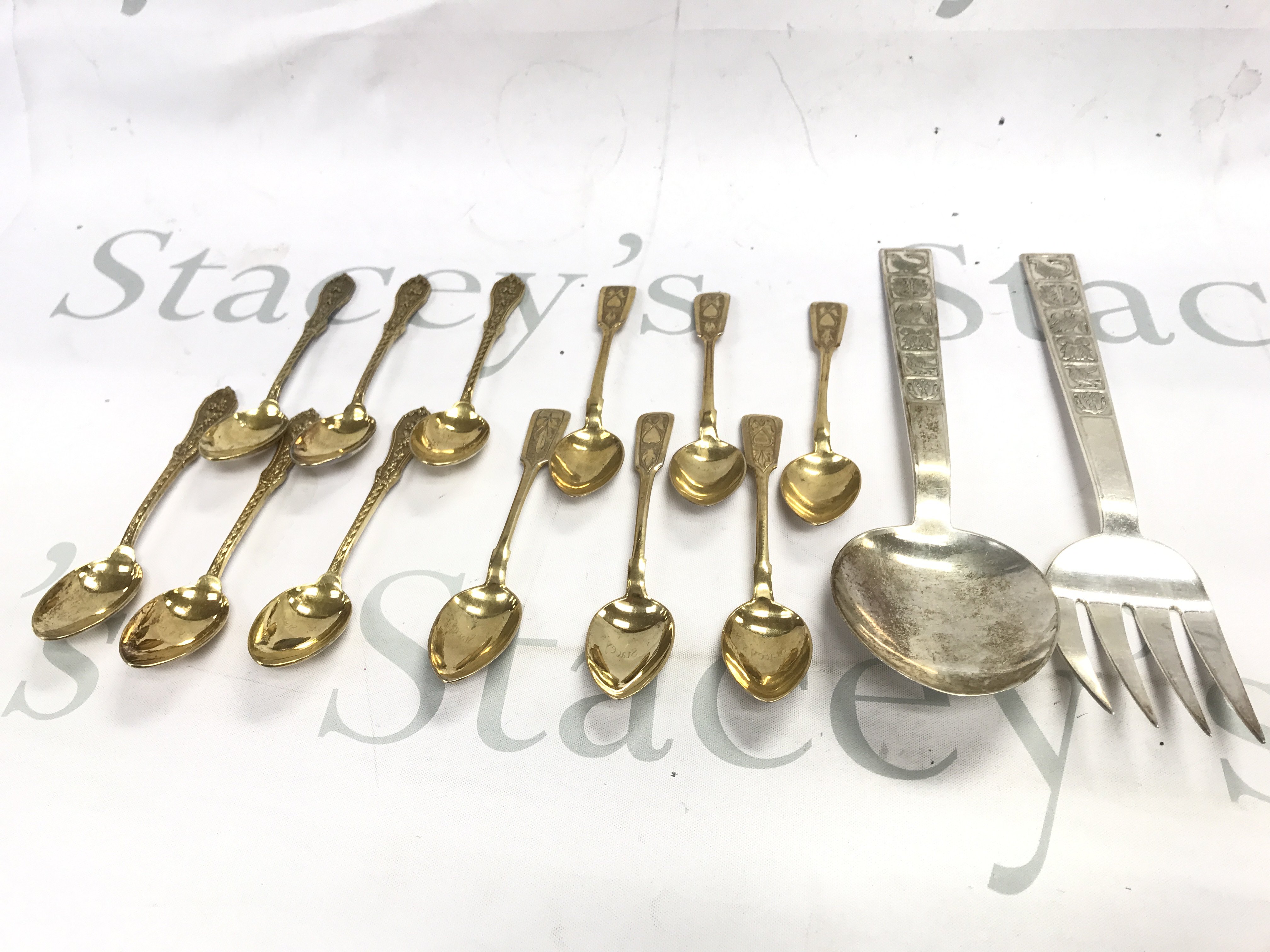 Two sets of silver gilt tea spoons and a large silver spoon and fork. 480g total.