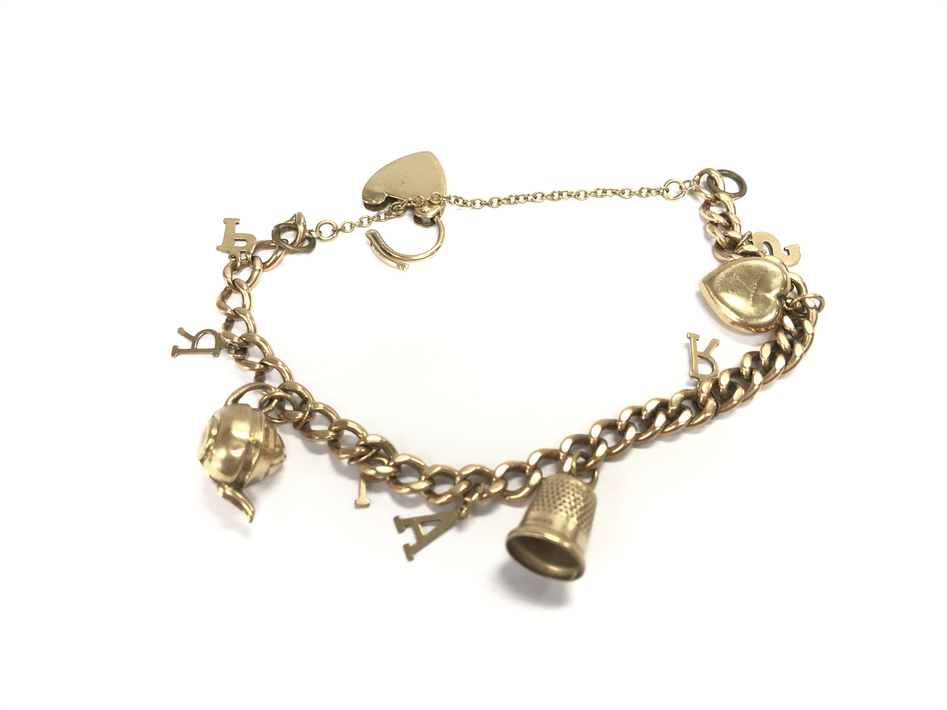 A 9ct gold charm bracelet with assorted charms. 18.58g