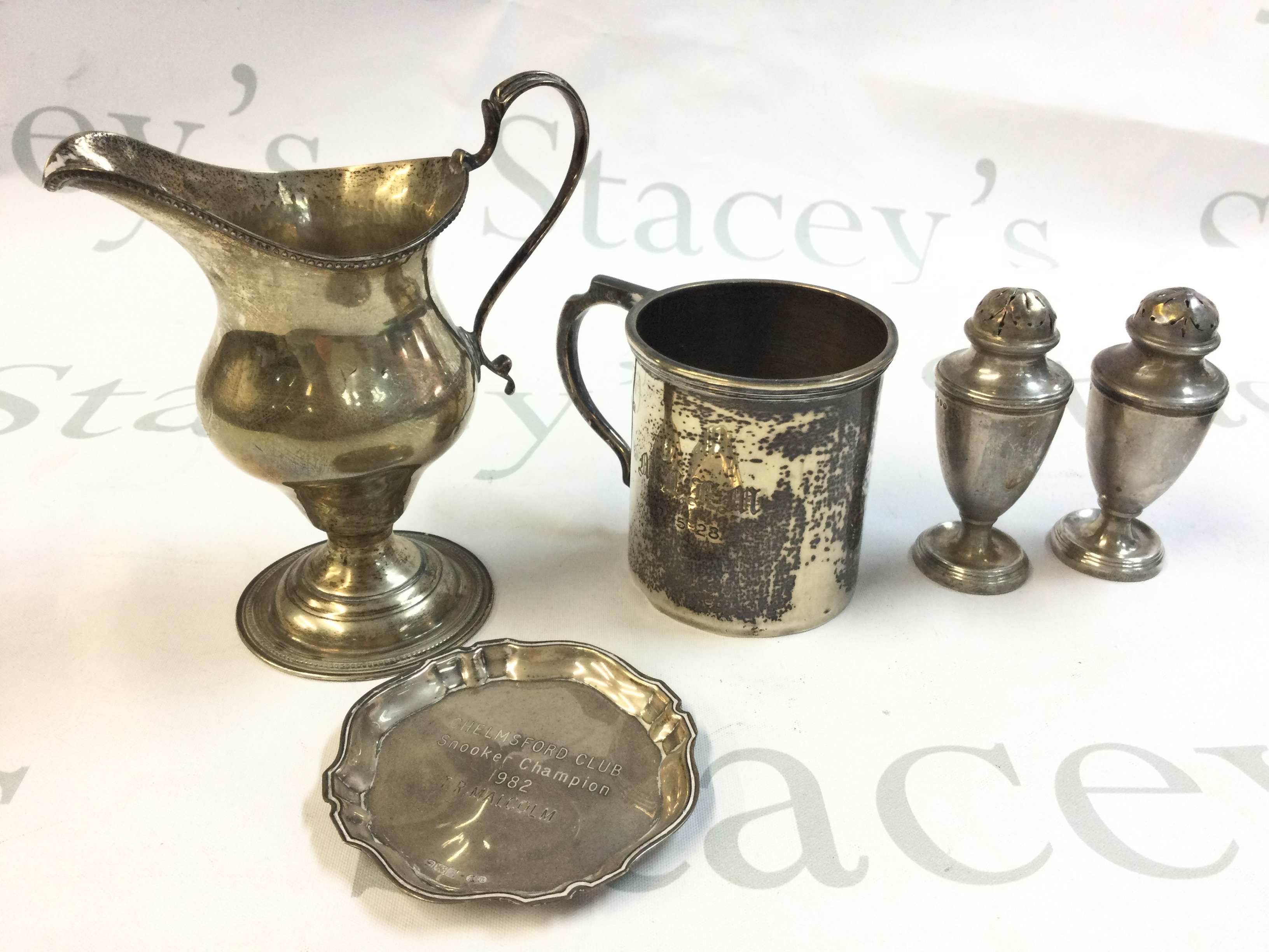 A collection of silver hallmarked items including a dish, S/P shakers, Mug and jug . Postage category B