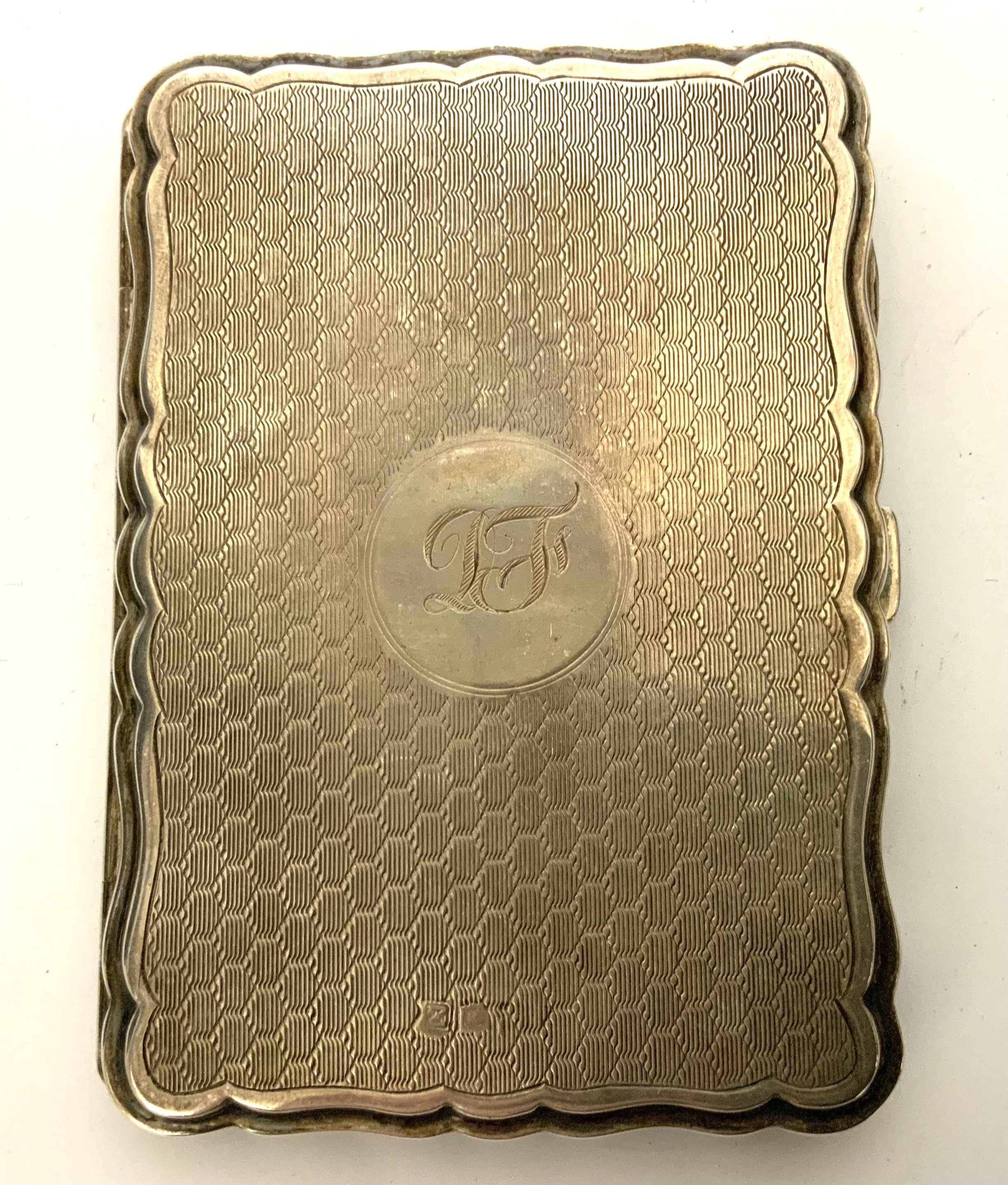 A hallmarked silver engine turned and leather lined pocket notebook. (A)